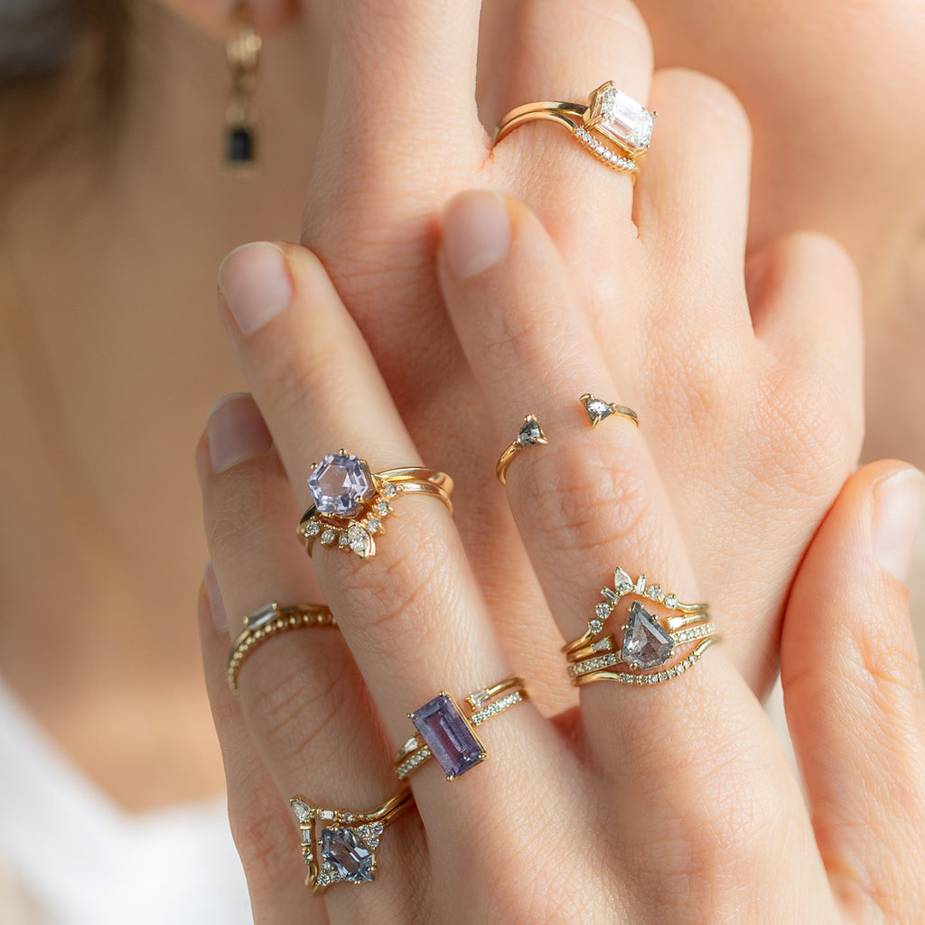 Model wearing yellow gold engagement rings with stacking bands