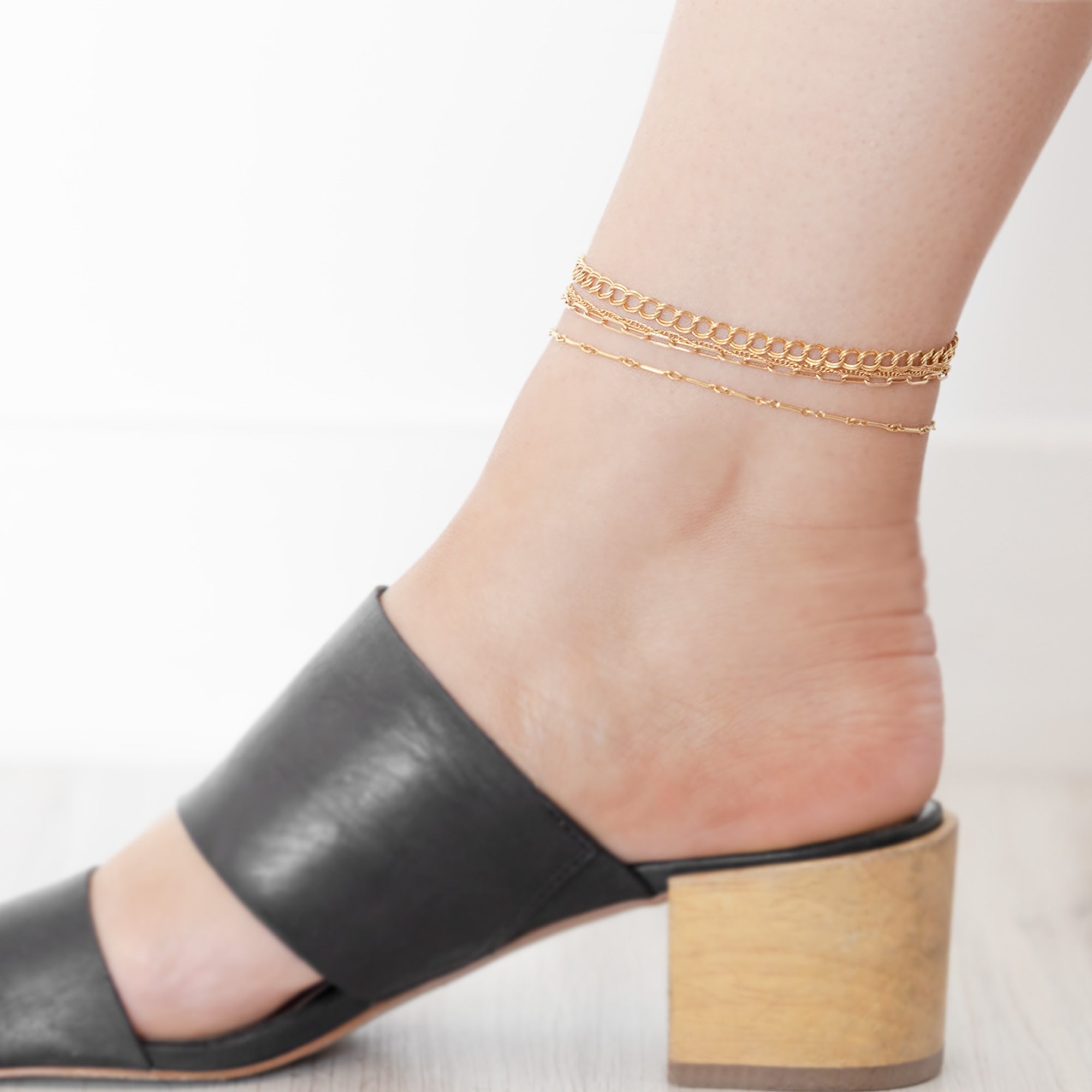 The Drawn Cable Chain Anklet in Yellow Gold Filled Stacked on Model