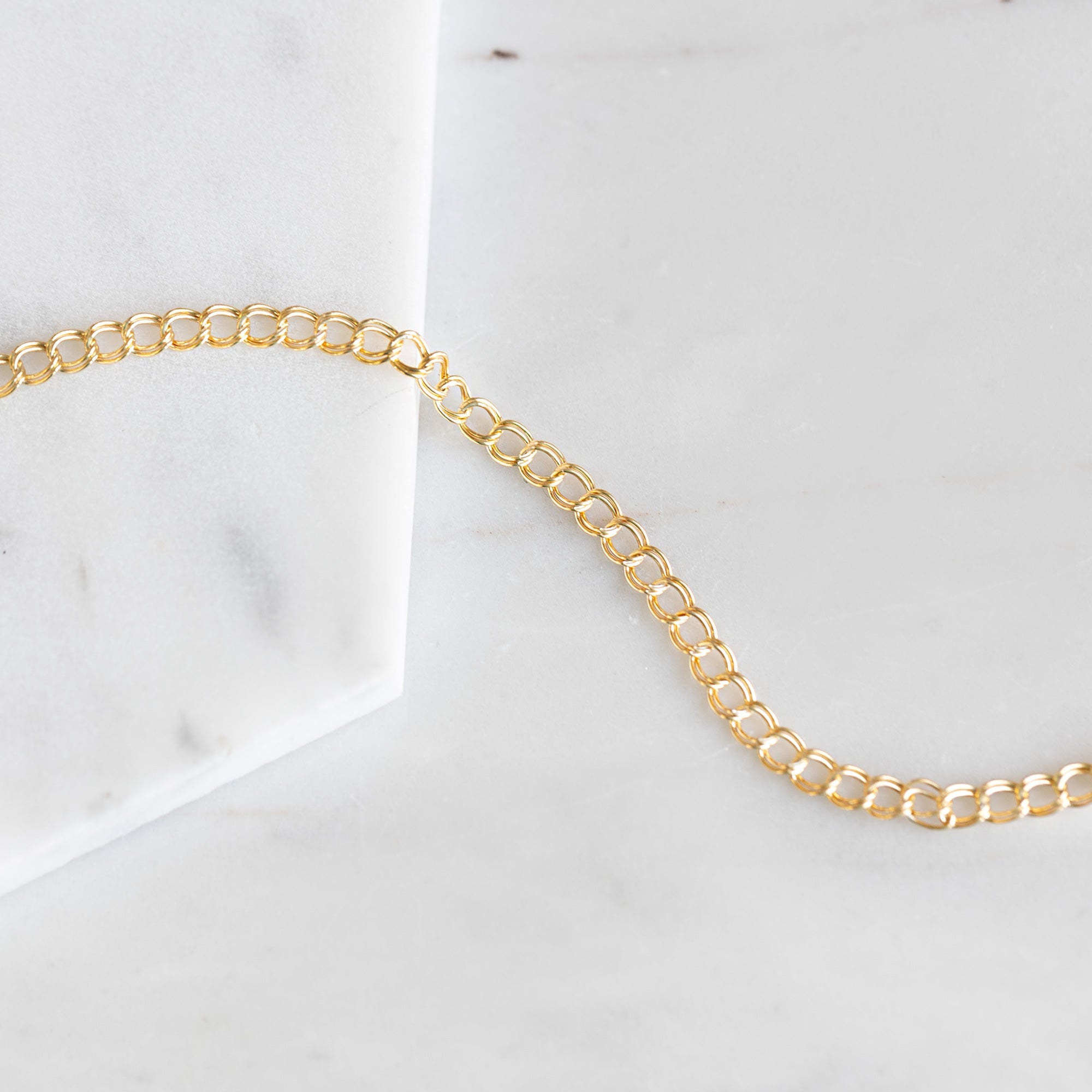 The Bold Curb Chain Bracelet in Yellow Gold Filled on White Marble