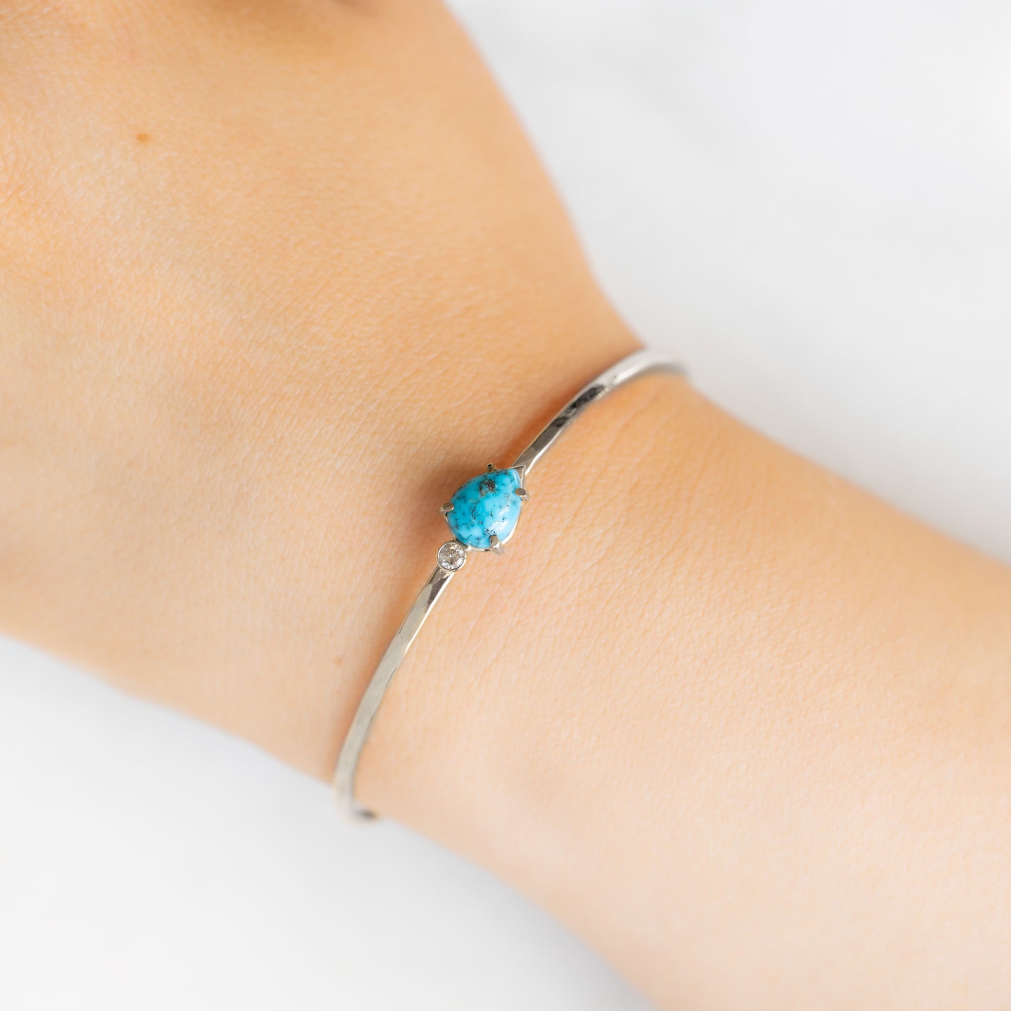 The Asymmetrical Turquoise + Diamond Cuff Bracelet in Sterling Silver on White Marble on Model