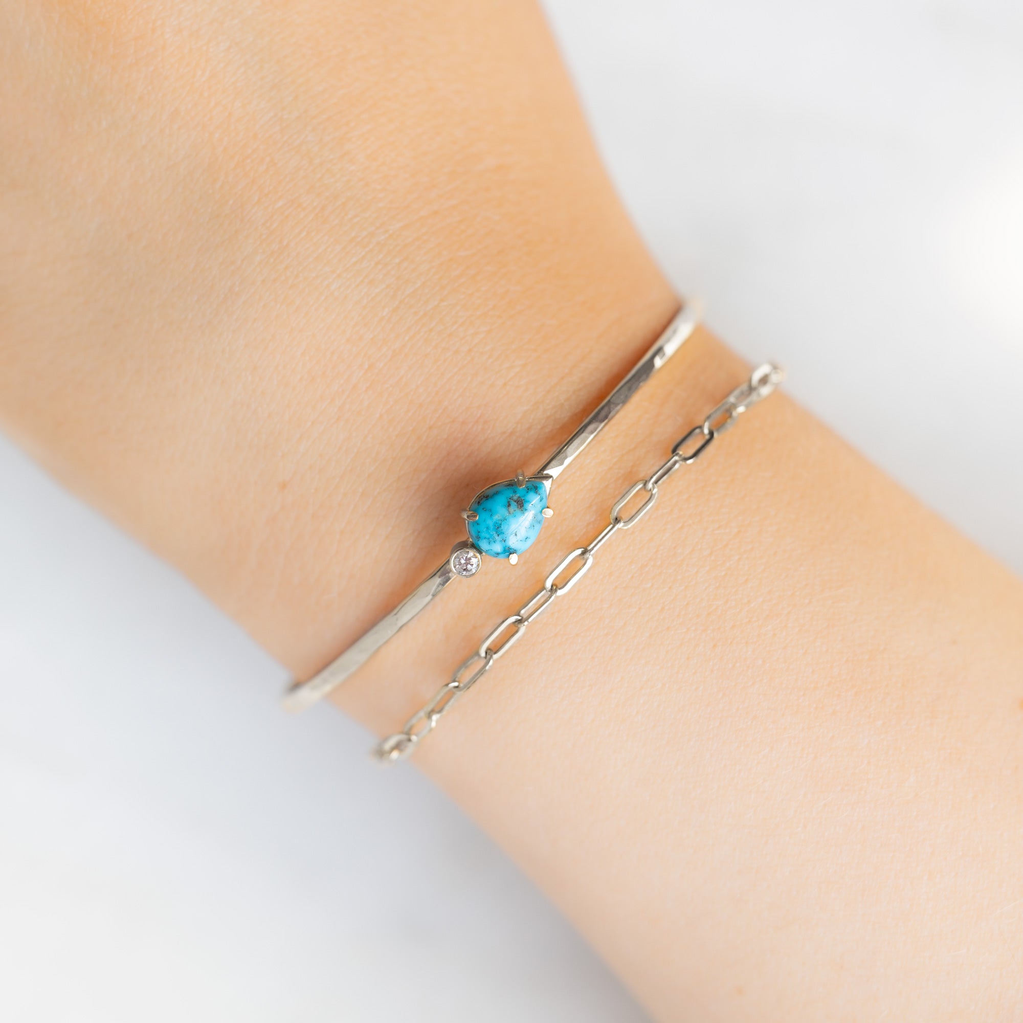 The Asymmetrical Turquoise + Diamond Cuff Bracelet in Sterling Silver Stacked on Model