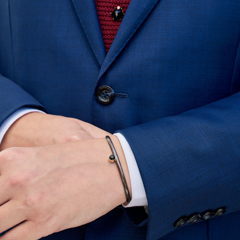 The Onyx Cuff Bracelet in Oxidized Sterling Silver on Model in Navy Blue Suit