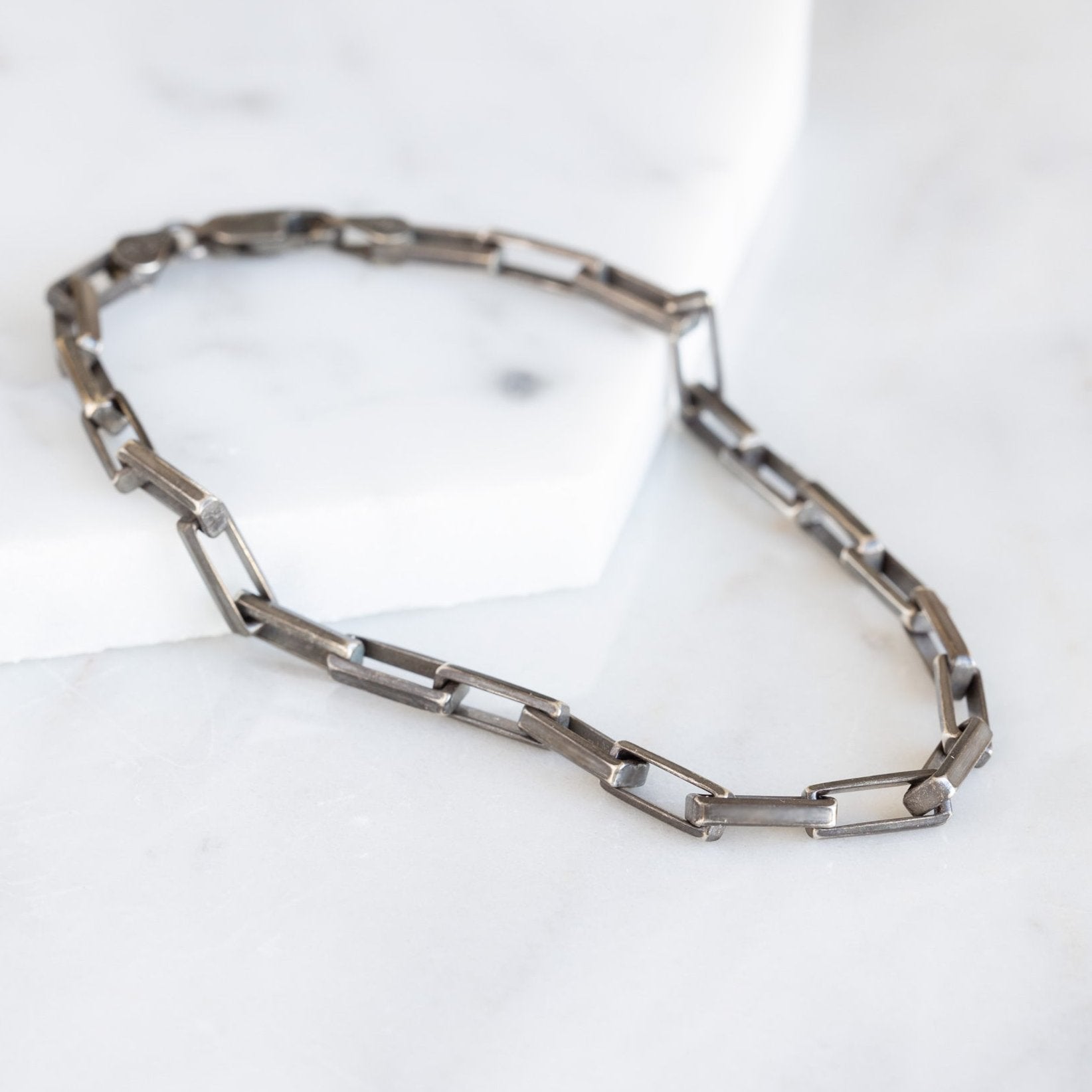 The Men's Drawn Cable Chain Bracelet in Oxidized Sterling Silver on White Marble