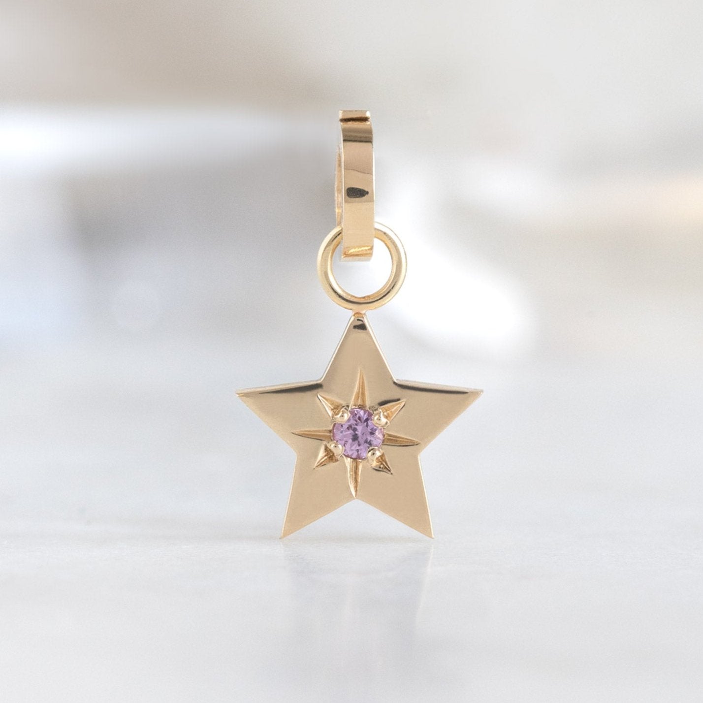 The Star Charm in 10K Yellow Gold on White Marble