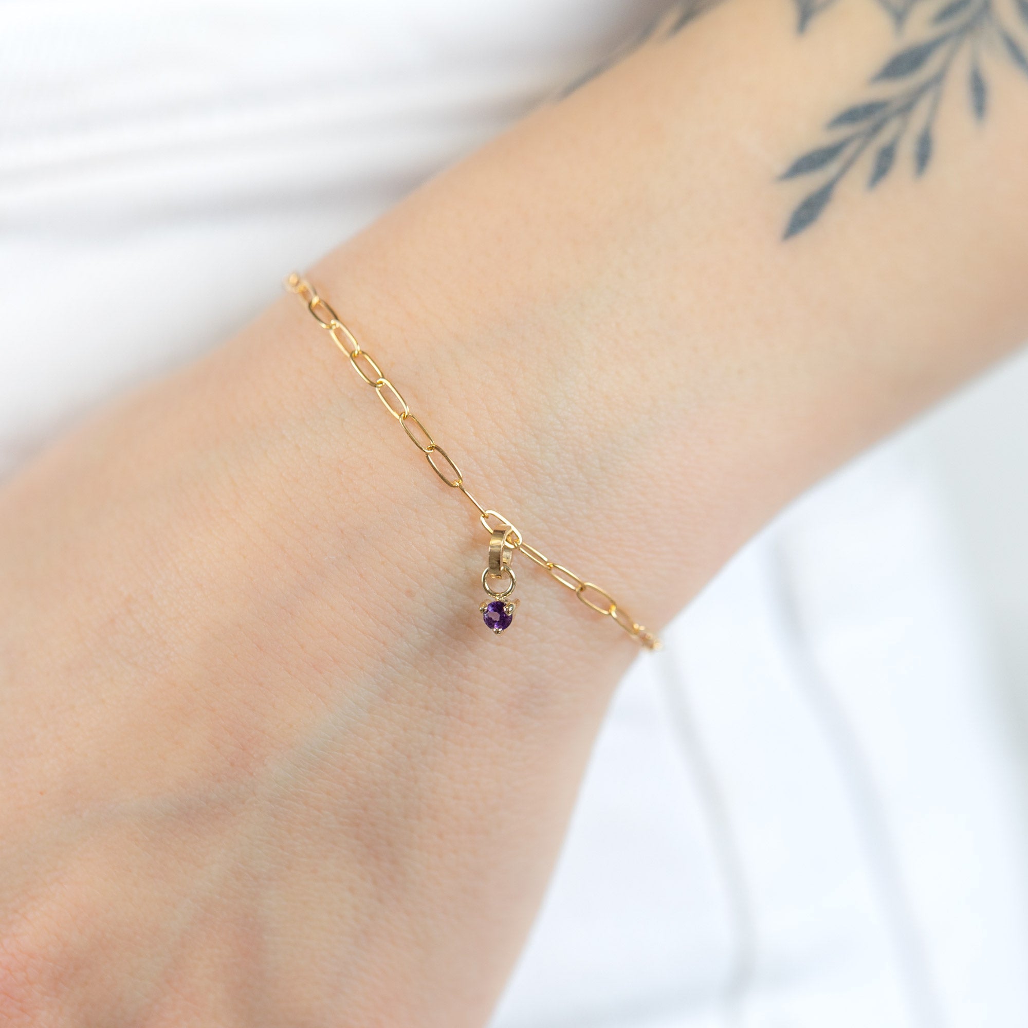 The Amethyst Birthstone Charm in 10K Yellow Gold on Drawn Cable Chain Bracelet on Model