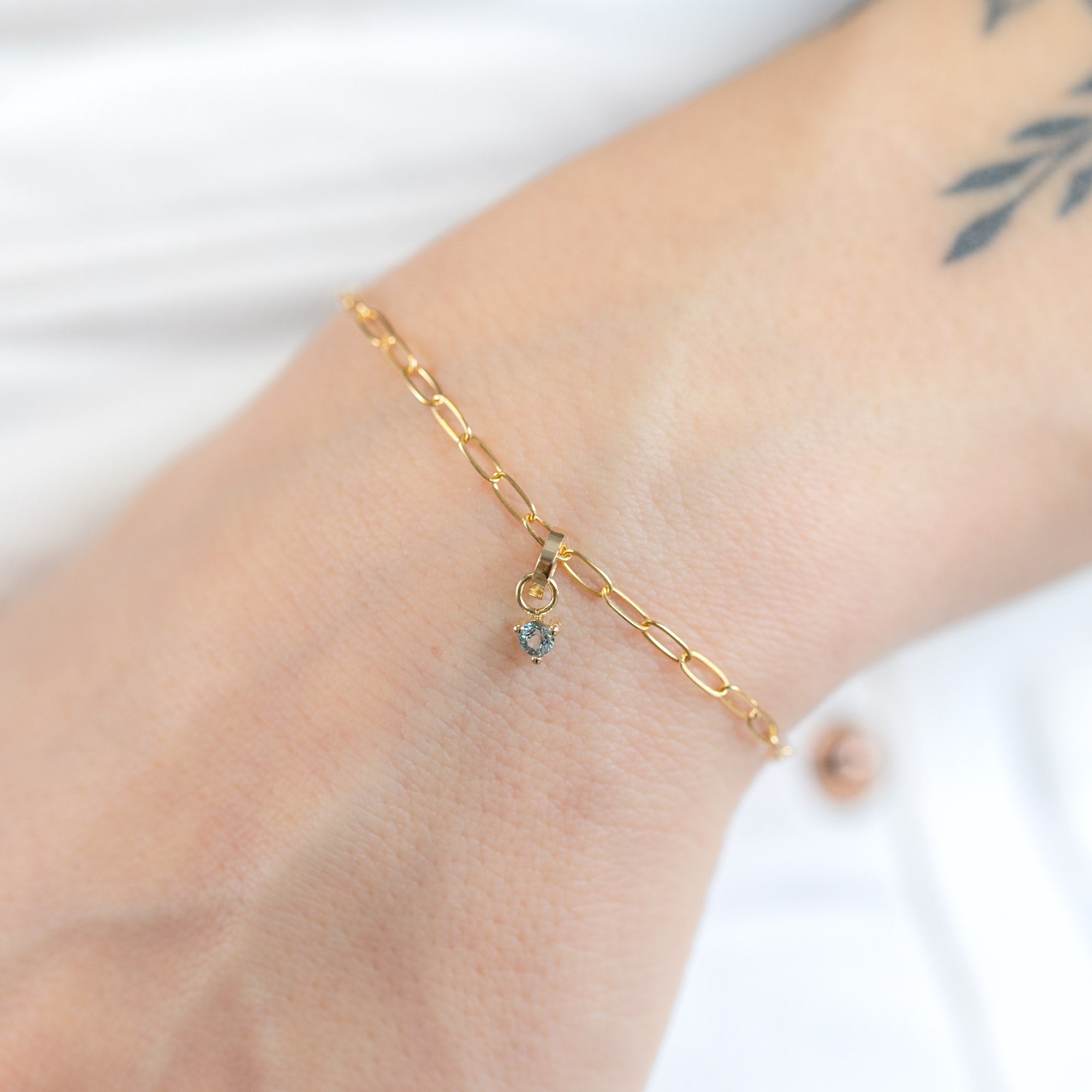 The Aquamarine Birthstone Charm in 10K Yellow Gold on Drawn Cable Chain Bracelet on Model