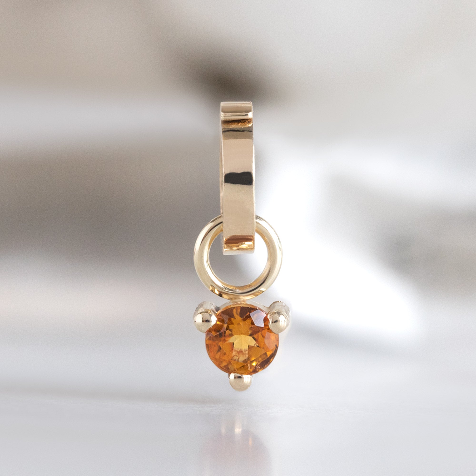 The Citrine Birthstone Charm in 10K Yellow Gold on White Marble