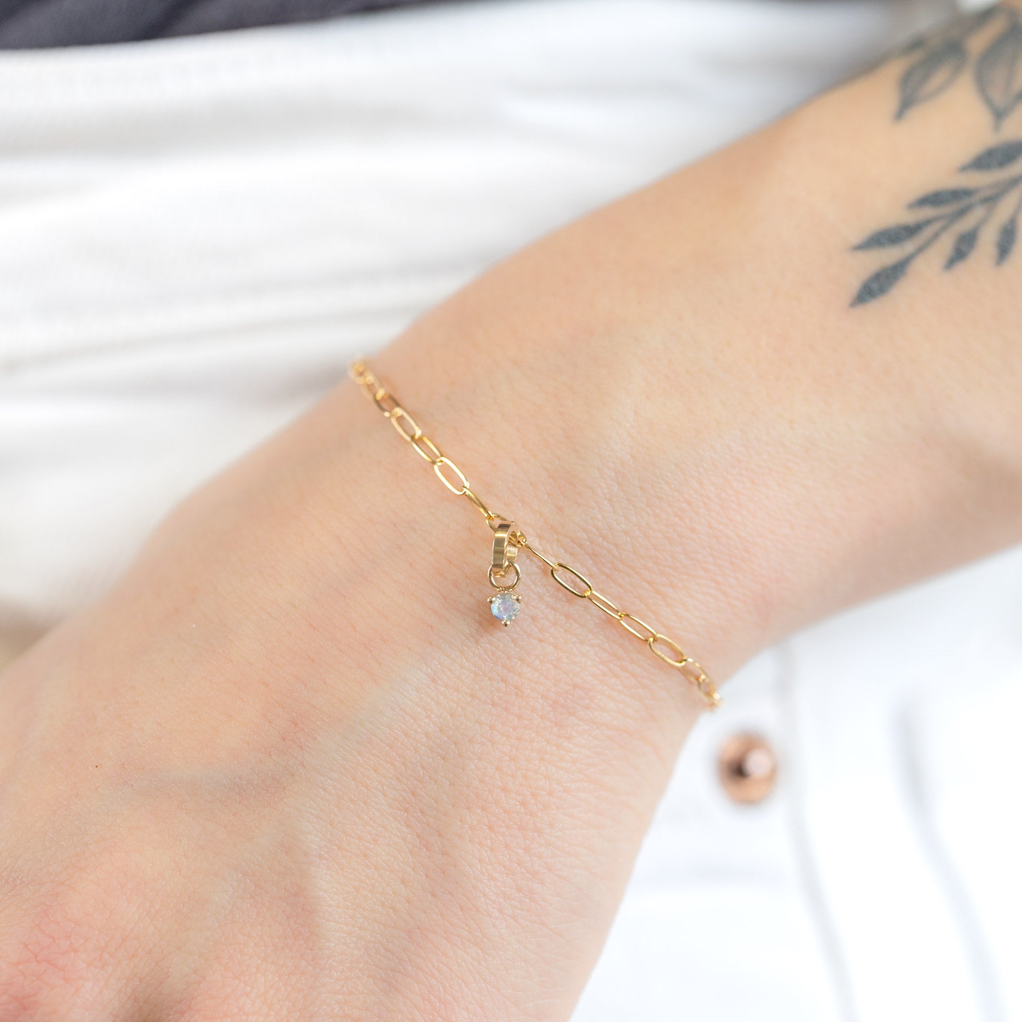 The Moonstone Birthstone Charm in 10K Yellow Gold on Drawn Cable Chain Bracelet on Model