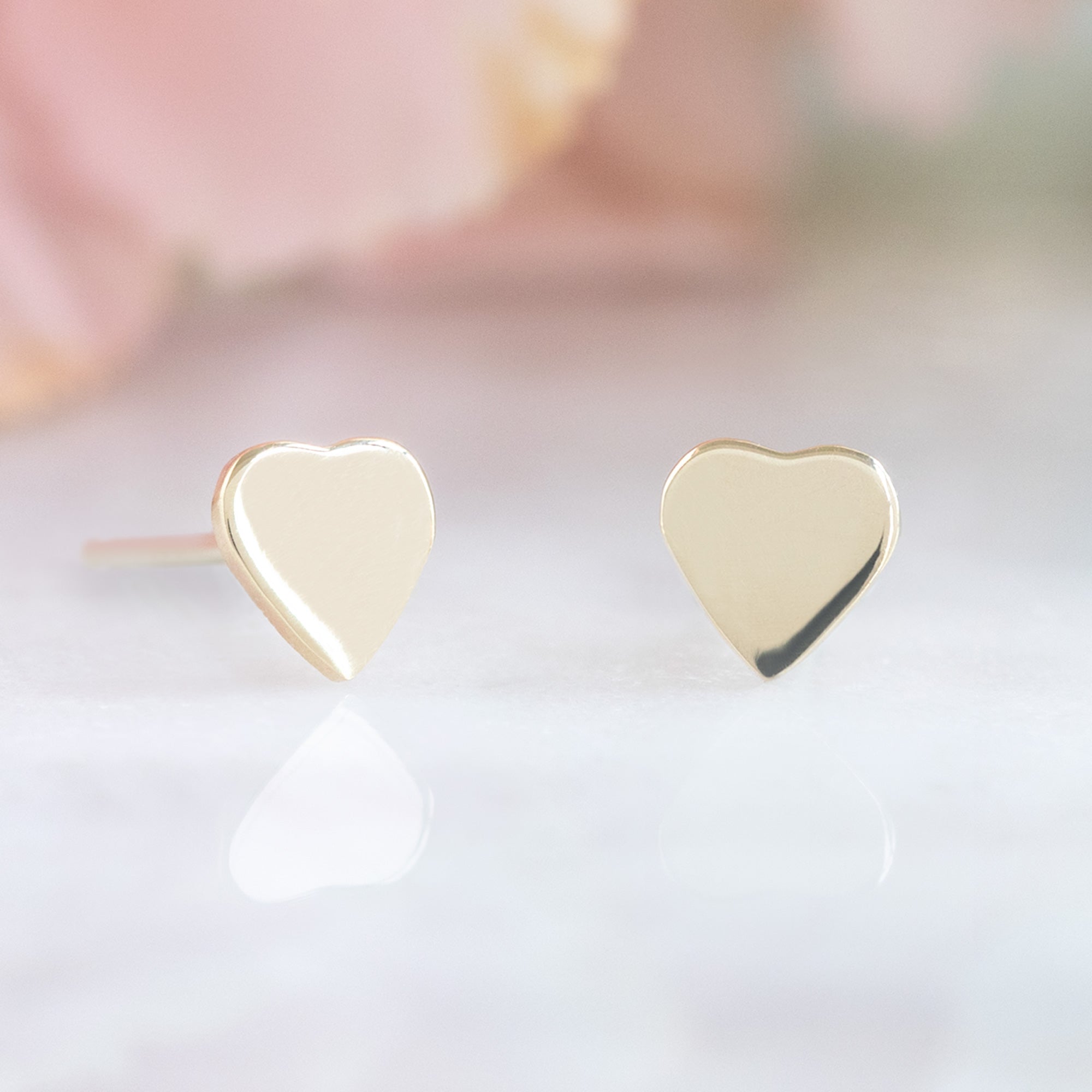 The Sweetheart Stud Earrings in 10K Yellow Gold on White Marble