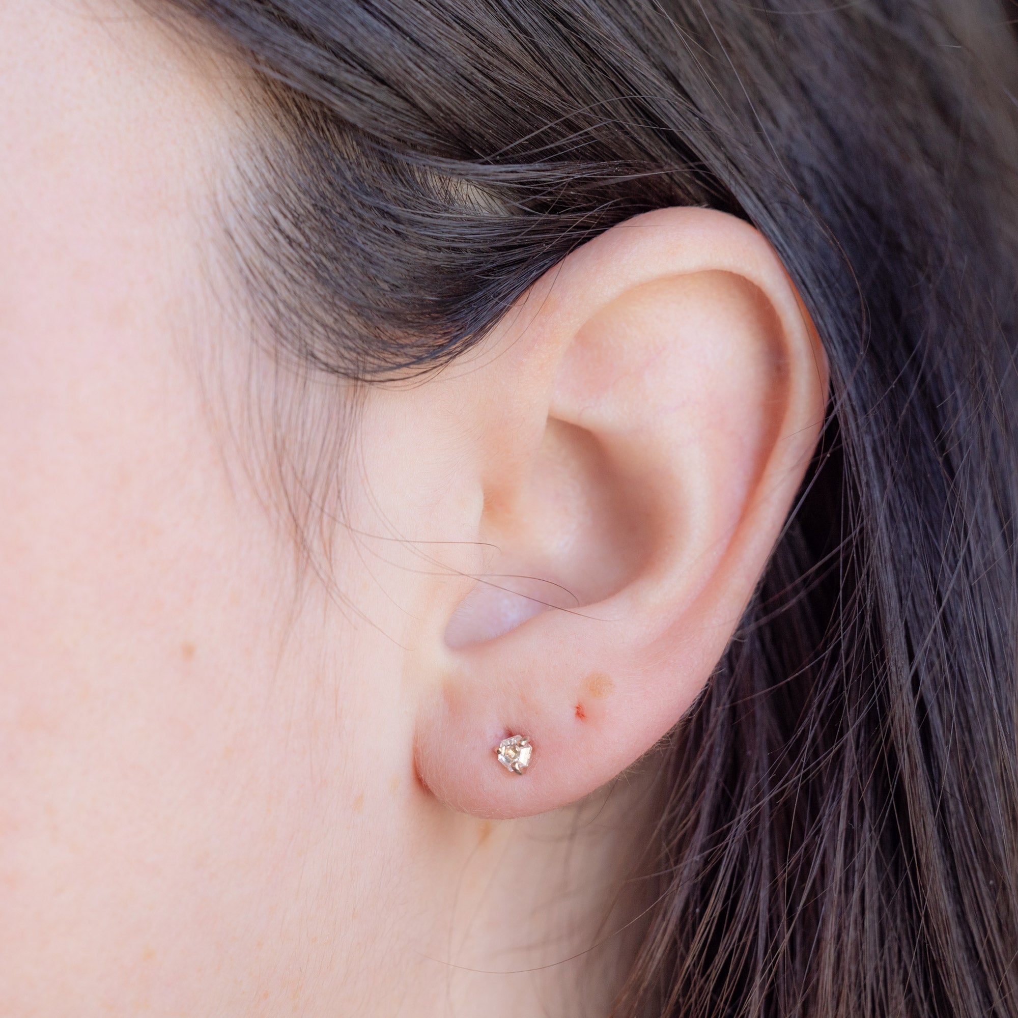 The Teensy White Diamond Hexagon Stud Earrings in 14K Rose Gold on Model