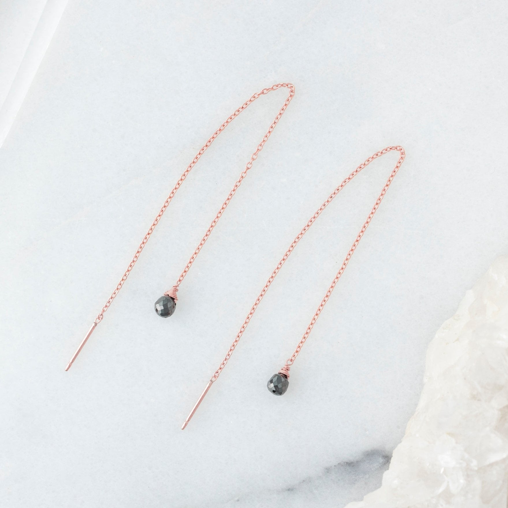 The Simple Black Diamond Drop Thread Earrings in Rose Gold Filled laying on white marble