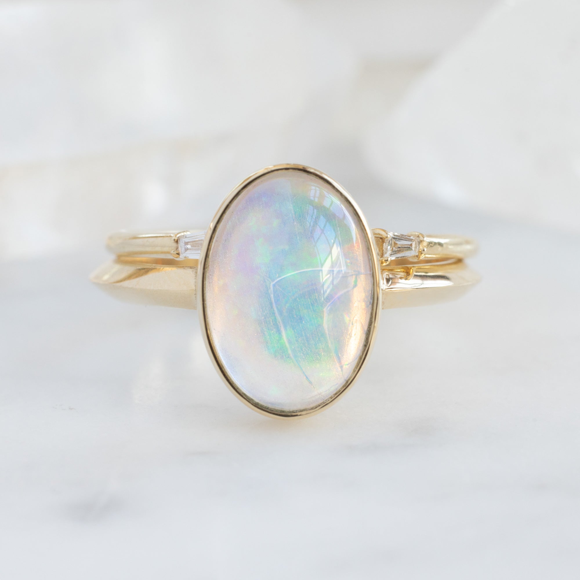 The Hazel Ring with a 1.97ct Oval Opal in 14K Yellow Gold with Open Cuff Baguette Stacking Band on white background