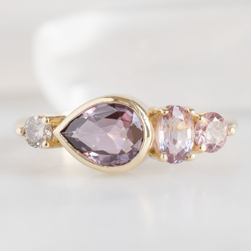 The Watercolor Ring with a 1.27ct Pear Magenta Sapphire in 14K Yellow Gold on White Background