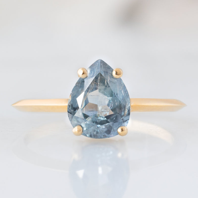 The Bryn Ring with a 1.42ct Pear Cut Blue Sapphire in 14K Yellow Gold on white background