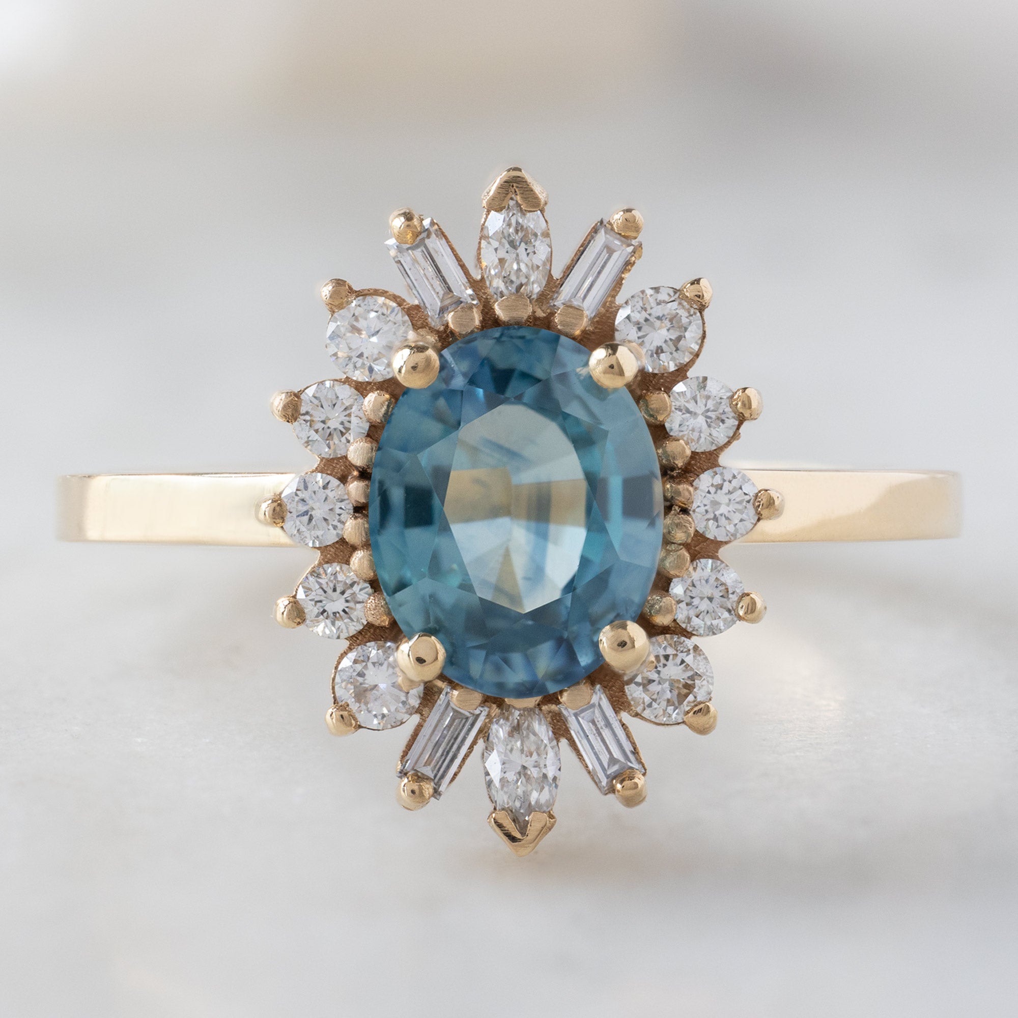 The Camellia Ring with a 1.32ct Oval Blue Montana Sapphire in 14K Yellow Gold