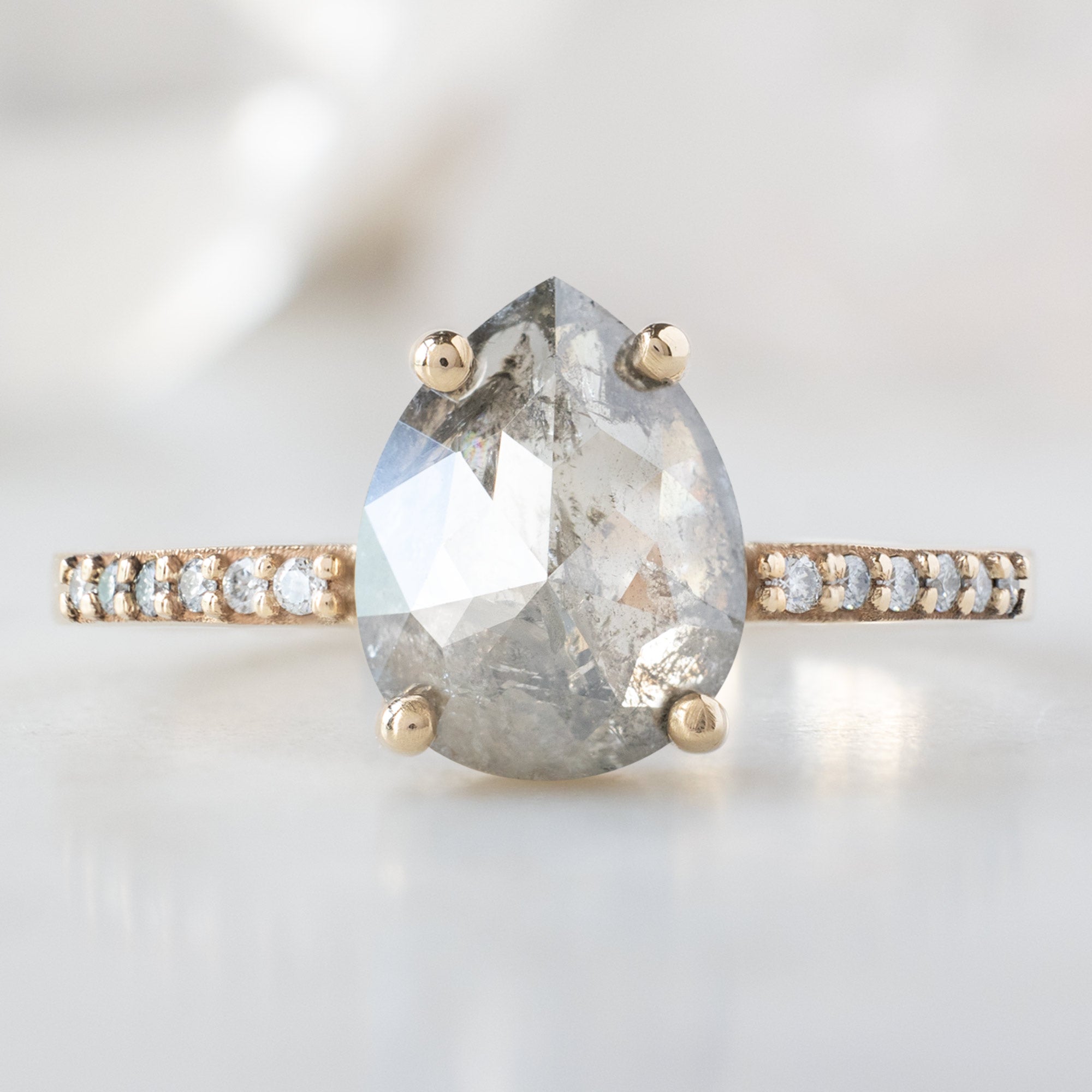 The Willow Ring with a 1.78ct Pear Salt and Pepper Diamond in 14K Yellow Gold on White Marble