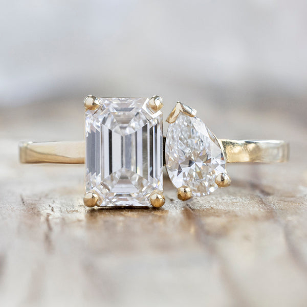 The You & Me Ring with a 1.50ct Emerald Cut Lab Grown White Diamond in 14K Yellow Gold on Wood Table