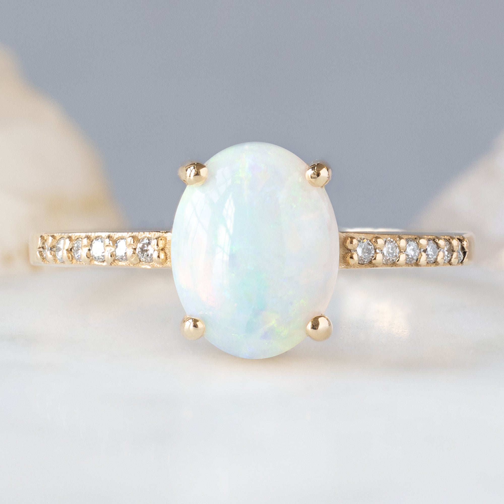 The Willow Ring with a 1.11ct Oval Australian Opal in 14K Yellow Gold on White Marble