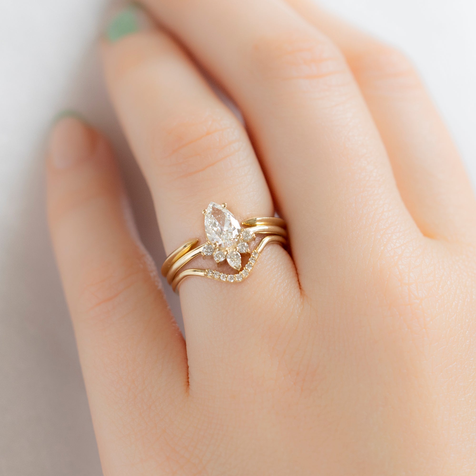 The Aster Ring with a 0.80ct Pear White Diamond in 14K Yellow Gold with Stacking Bands on Model