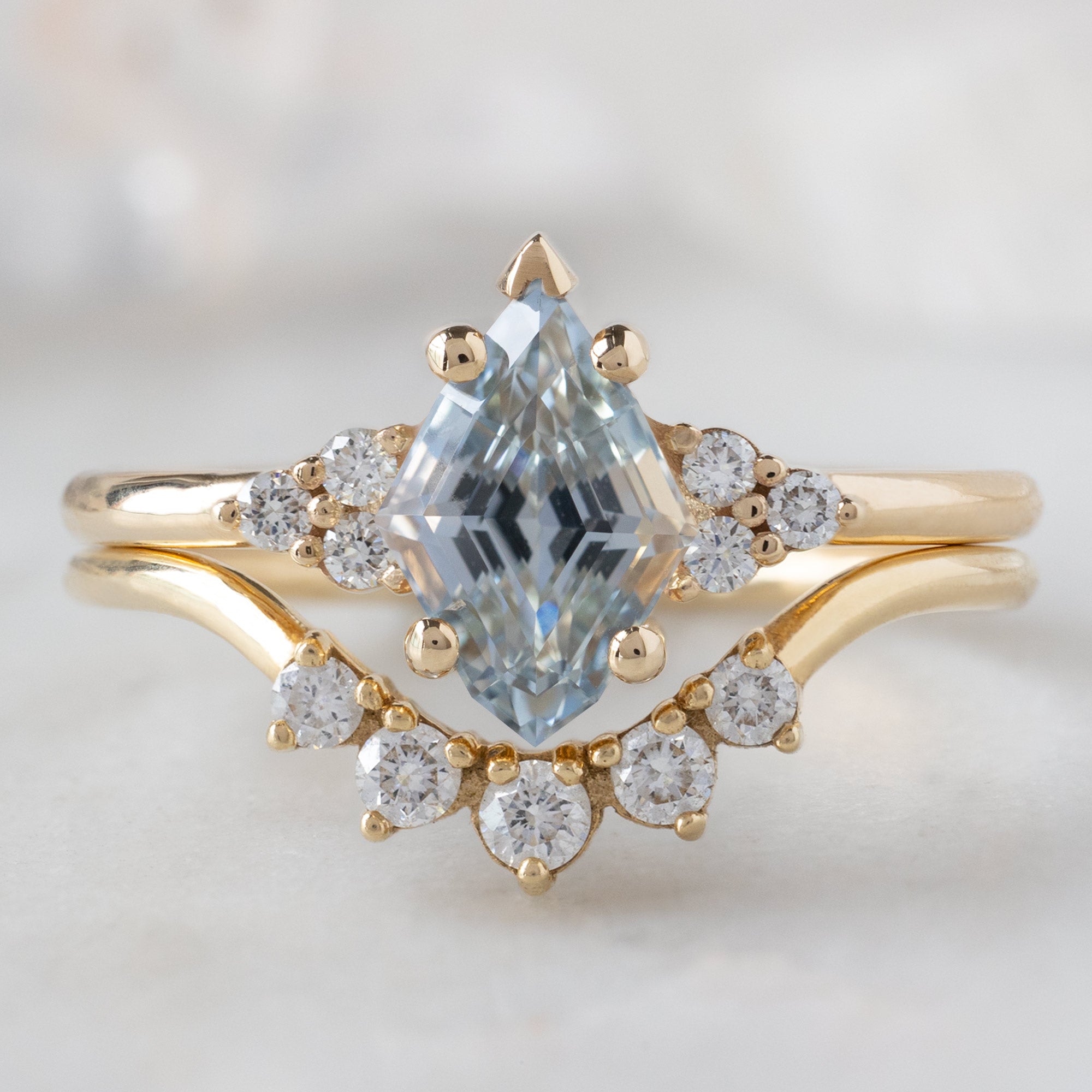 The Ivy Ring with a 1.37ct Kite Blue Sapphire in 14K Yellow Gold with the Round White Diamond Sunburst Stacking Band