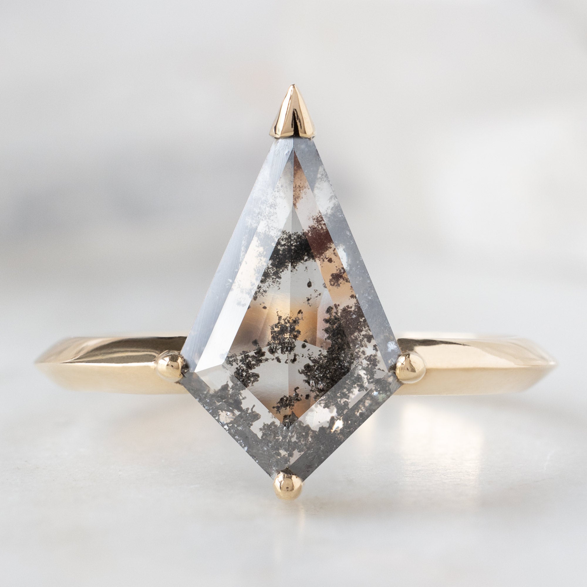 The Sage Ring with a 1.73ct Lab Grown Salt and Pepper Kite Diamond in 14K Yellow Gold on White Marble