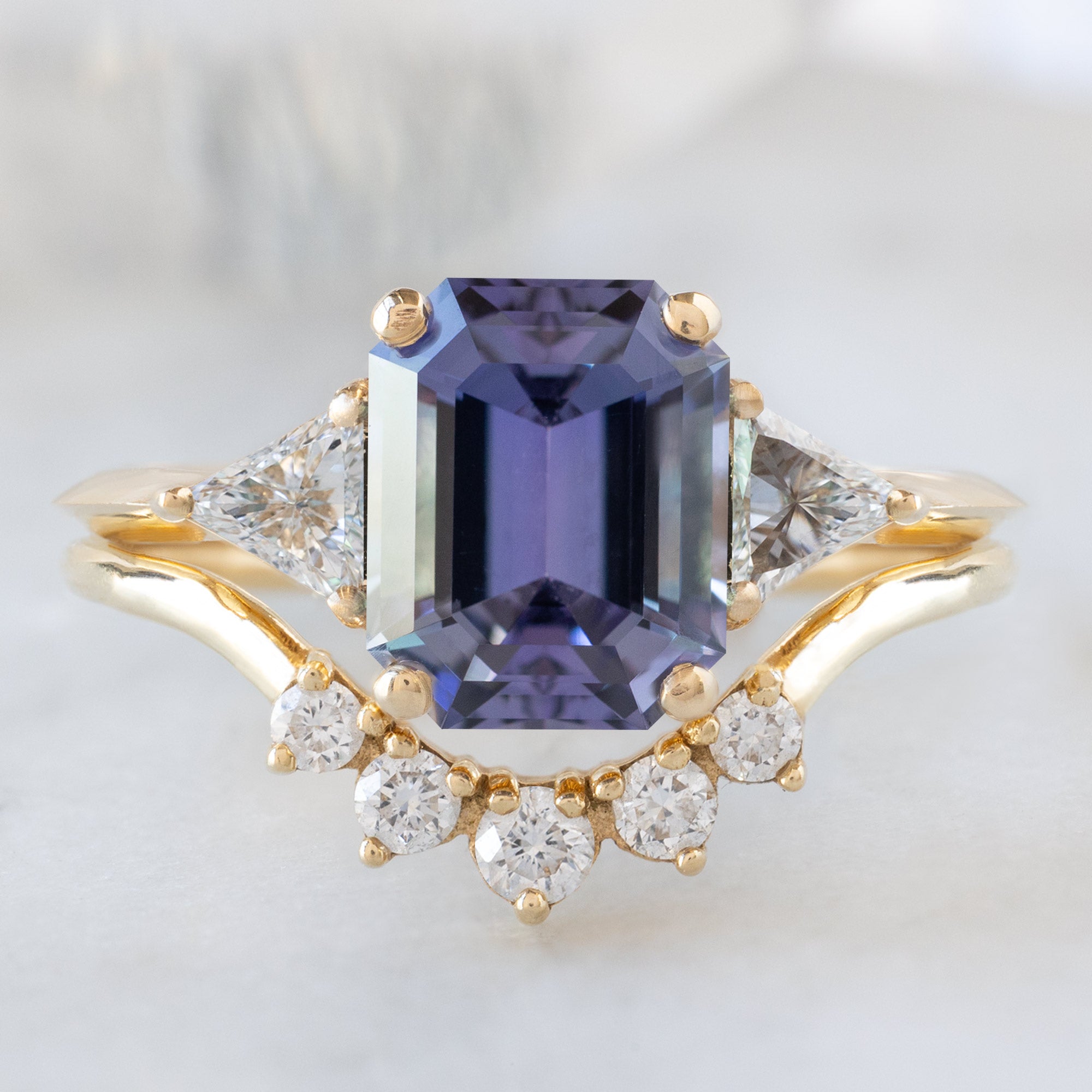 The Jade Ring with a 1.91ct Emerald Cut Purple Tanzanite in 14K Yellow Gold Stacked with the Round White Diamond Sunburst Stacking Band