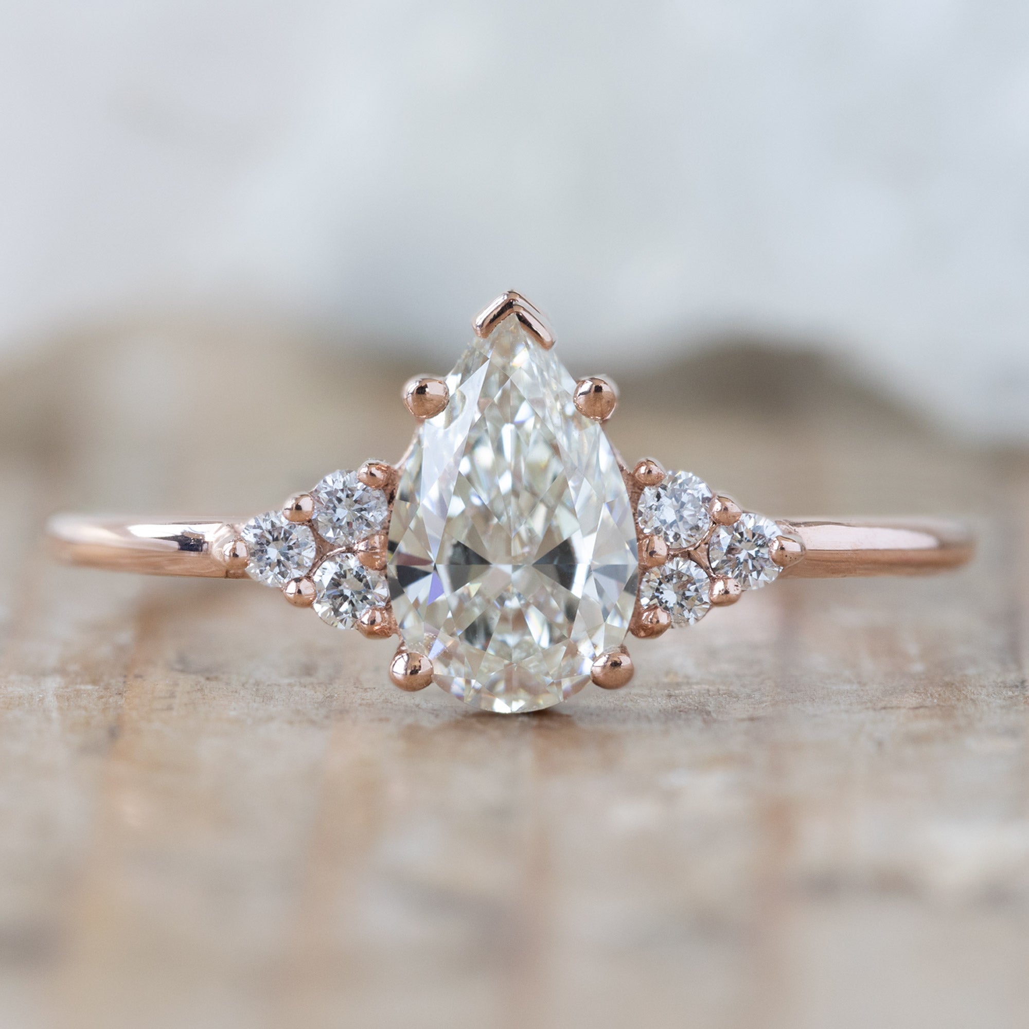 The Ivy Ring with a 0.70ct Pear White Diamond in 14k Rose Gold on Wood