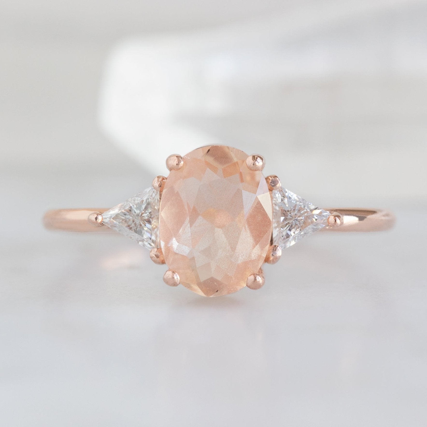 The Jade Ring with a 0.95ct Oval Sunstone in 14K Rose Gold on White Marble