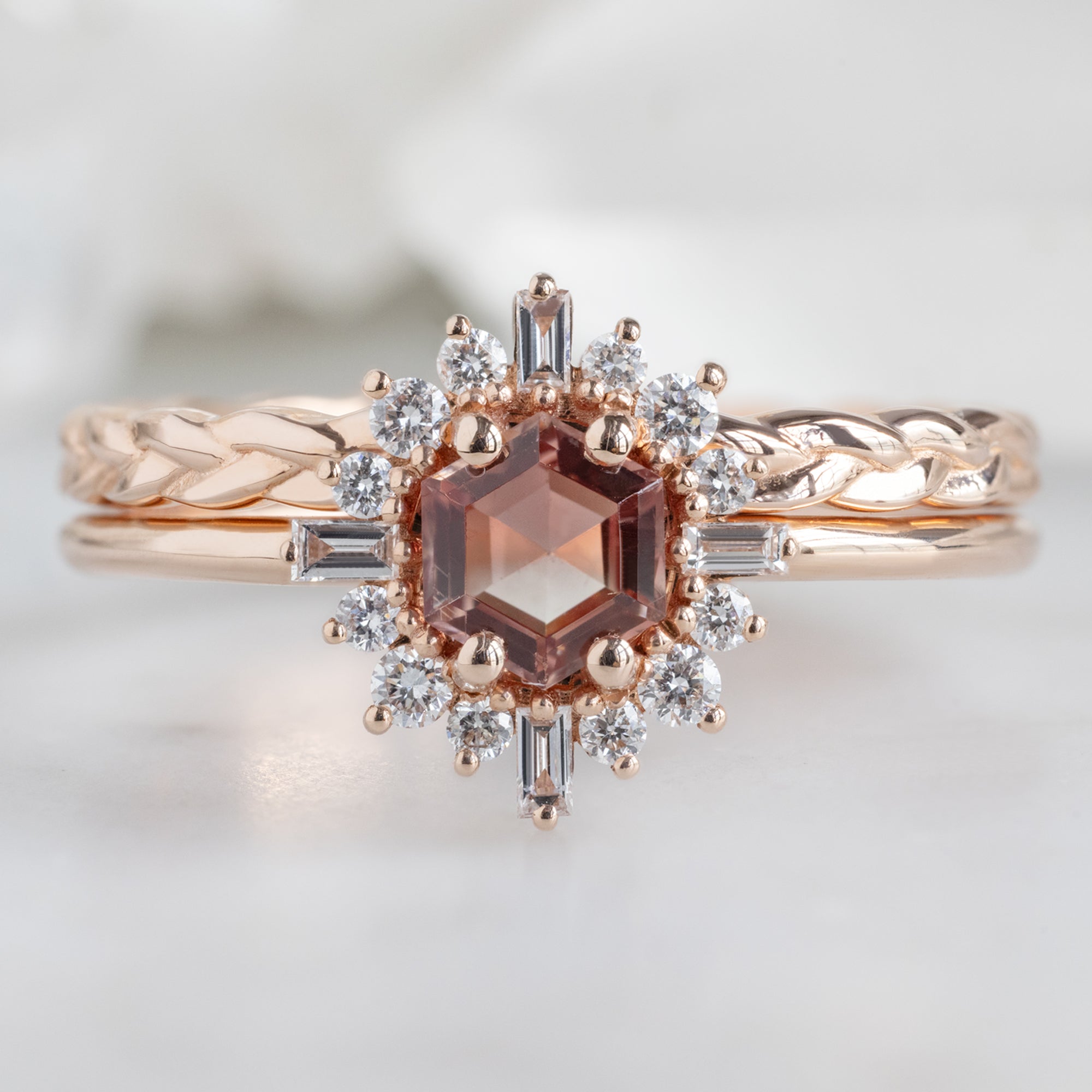 The Compass Ring with a 0.37ct Hexagon Sunstone in 14K Rose Gold Stacked with the Braided Wedding Band