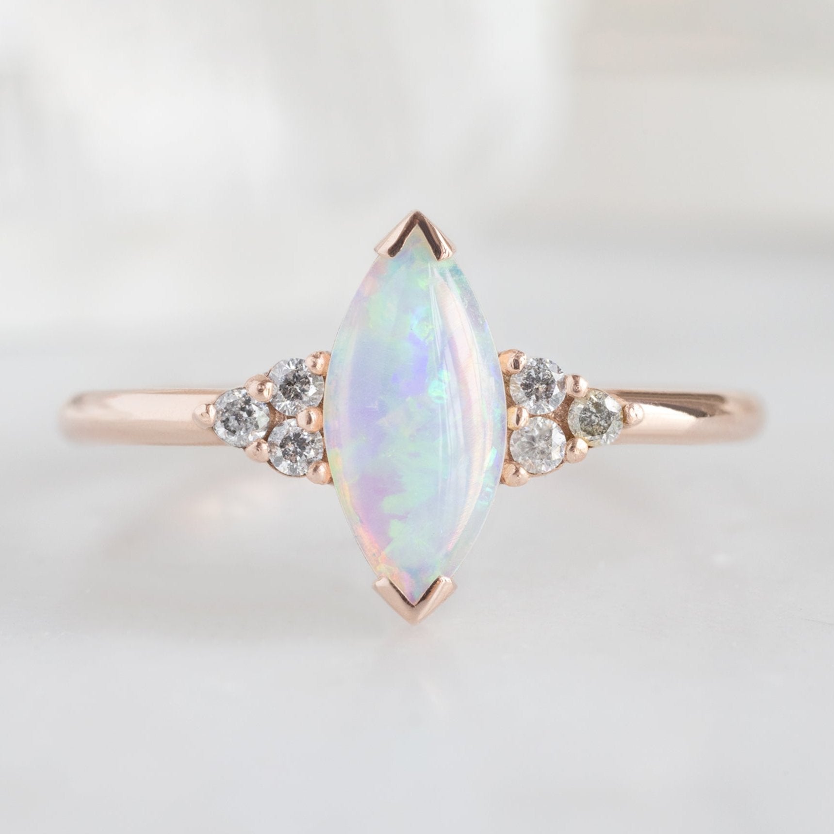 The Ivy Ring with a 0.37ct Marquise Opal in 14K Rose Gold on White Marble