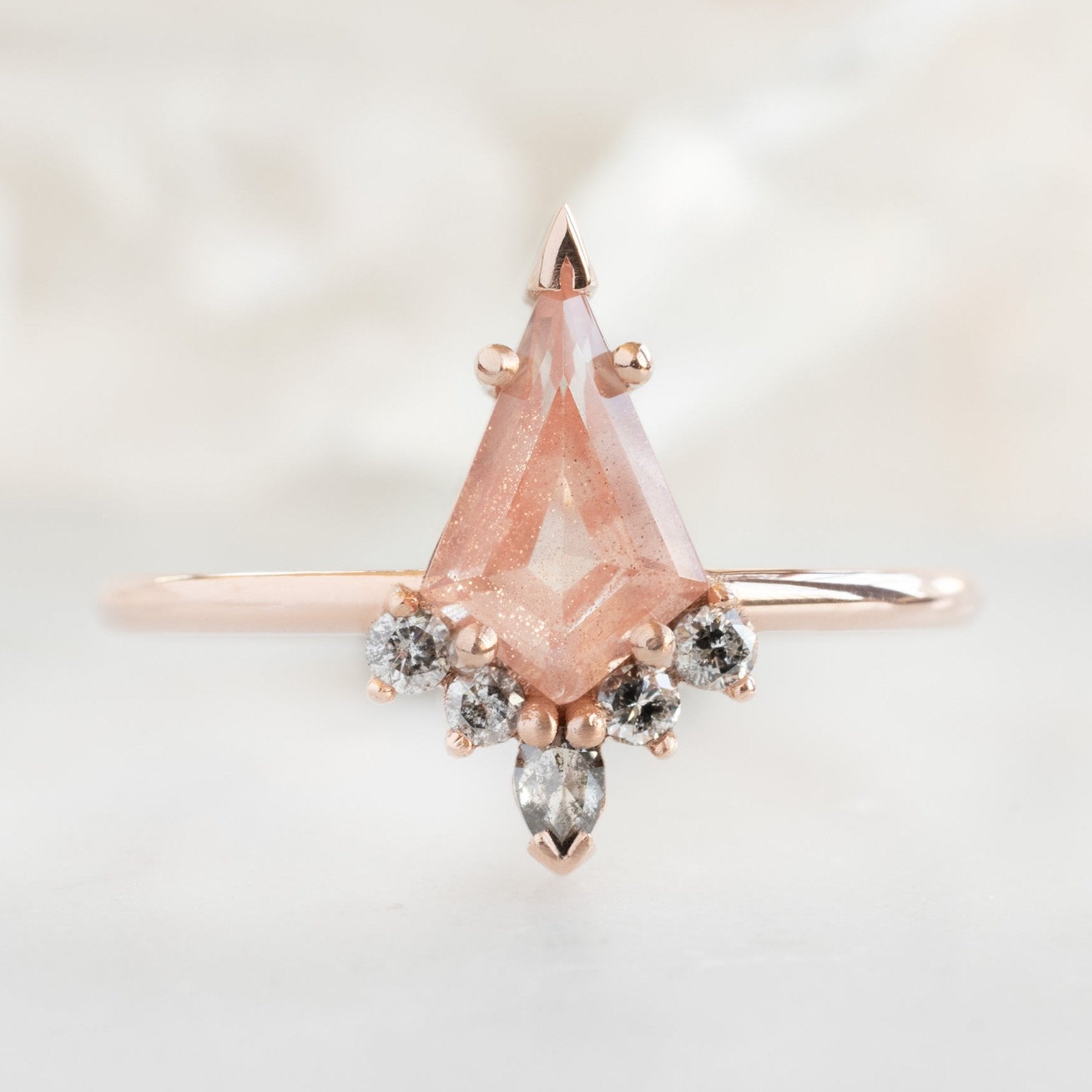 The Aster Ring | 0.79 carat Kite Sunstone in 14K Rose Gold with white blurred background.