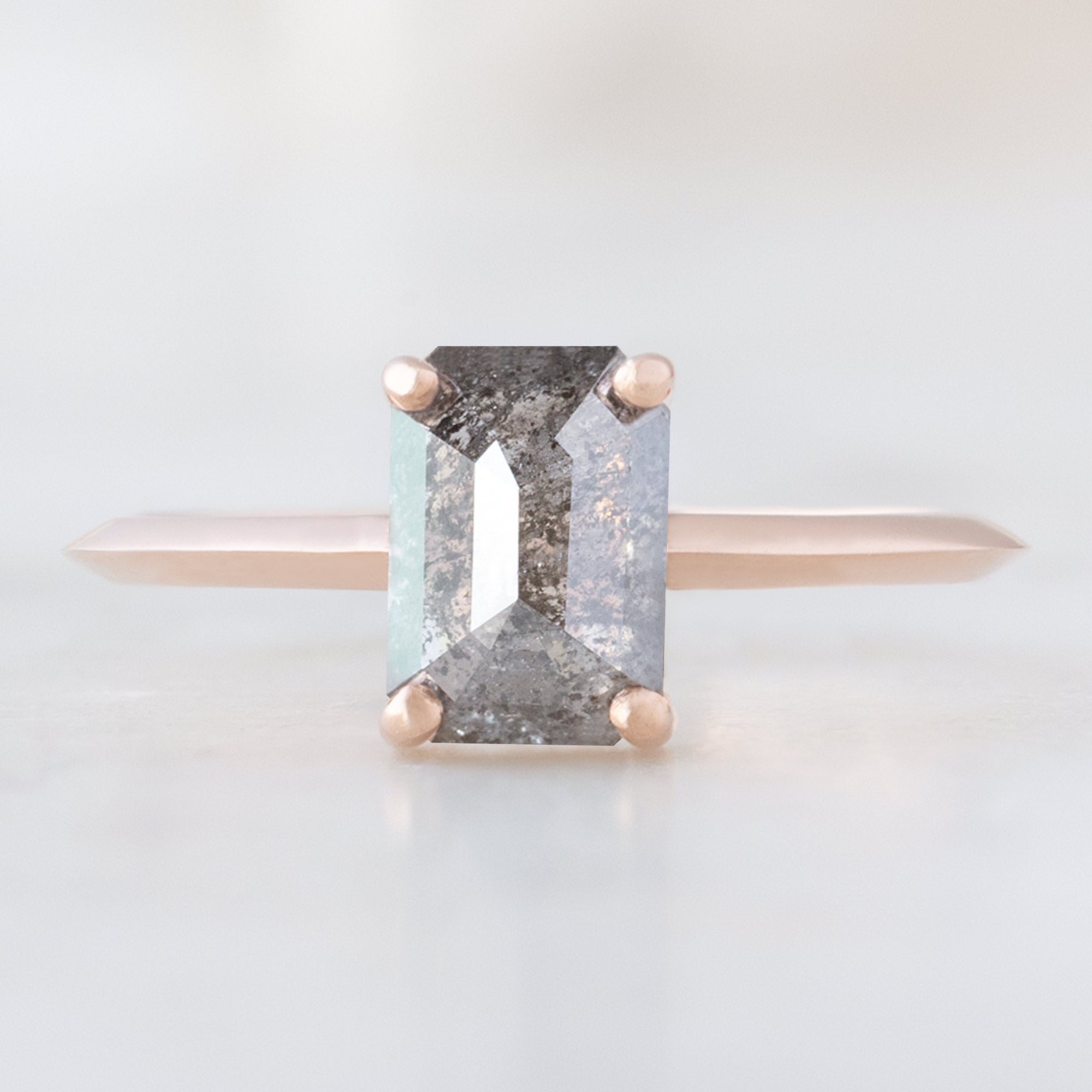 The Bryn Ring with a 1.26ct Emerald Cut Salt and Pepper Diamond in 14K Rose Gold on white background