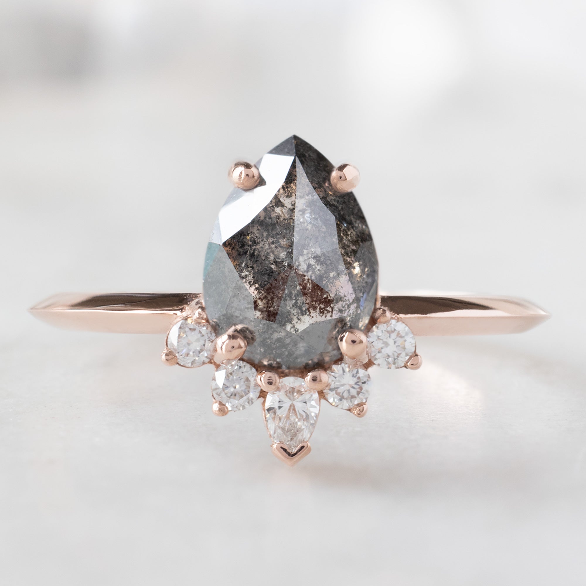 The Aster Ring with a 1.41ct Pear Black Diamond in 14K Rose Gold on White Marble