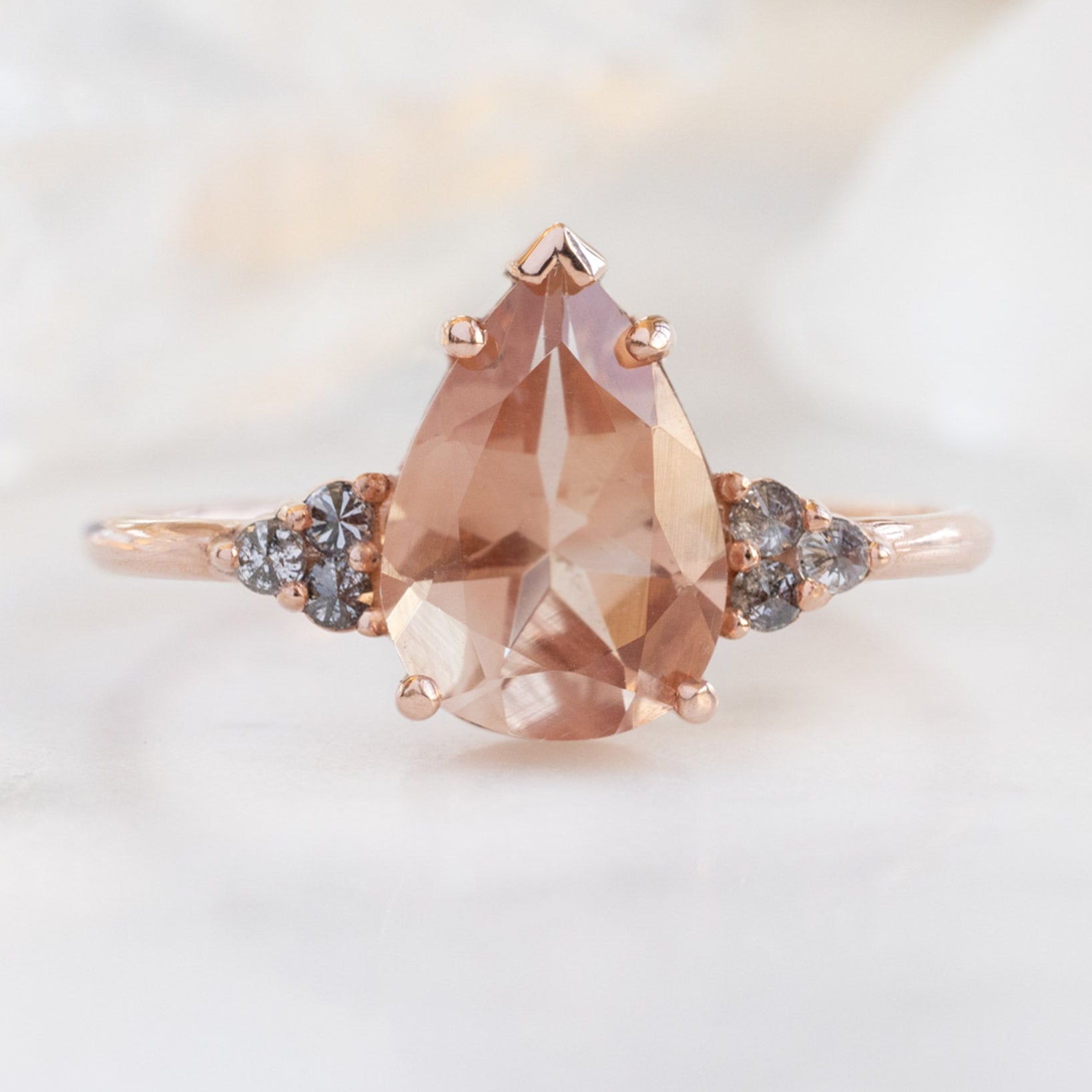 The Ivy Ring with a 1.87ct Pear Sunstone in 14K Rose Gold on White Marble