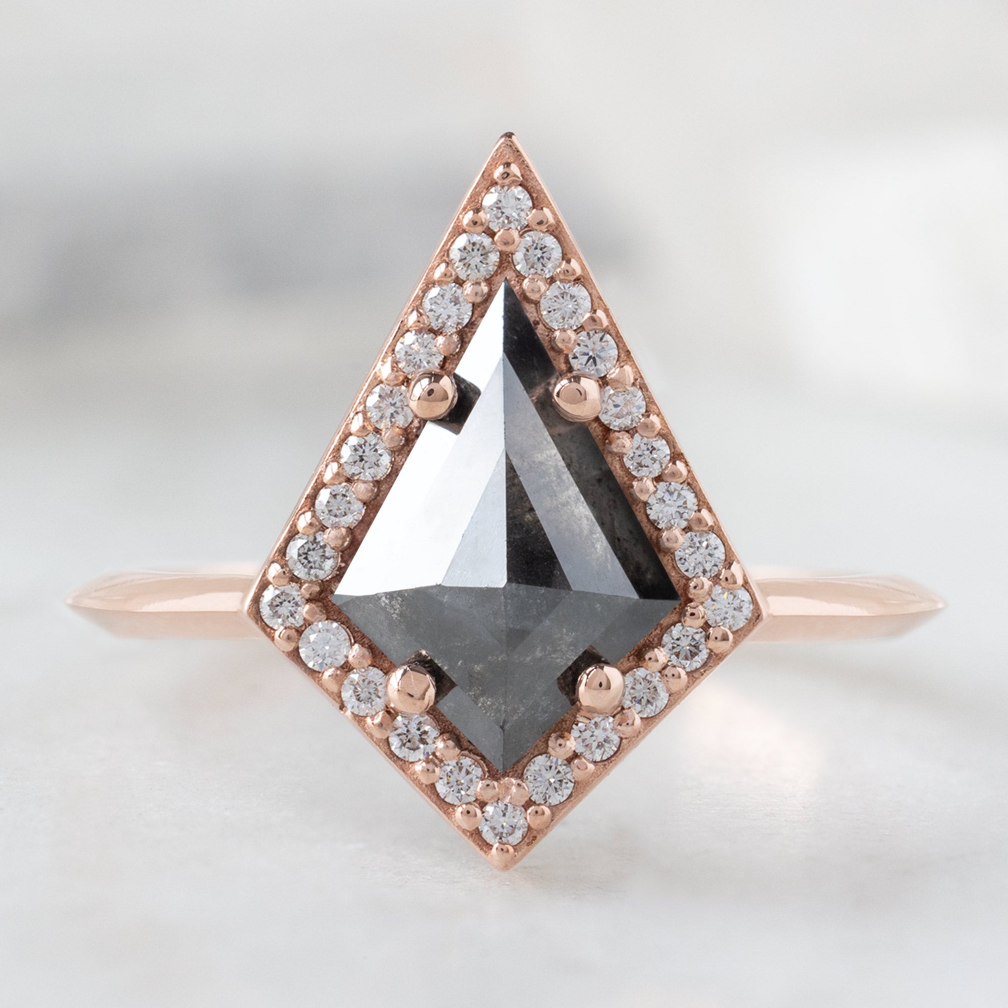 The Dahlia Ring with a 0.89ct Black Kite Diamond in 14K Rose Gold on White Marble