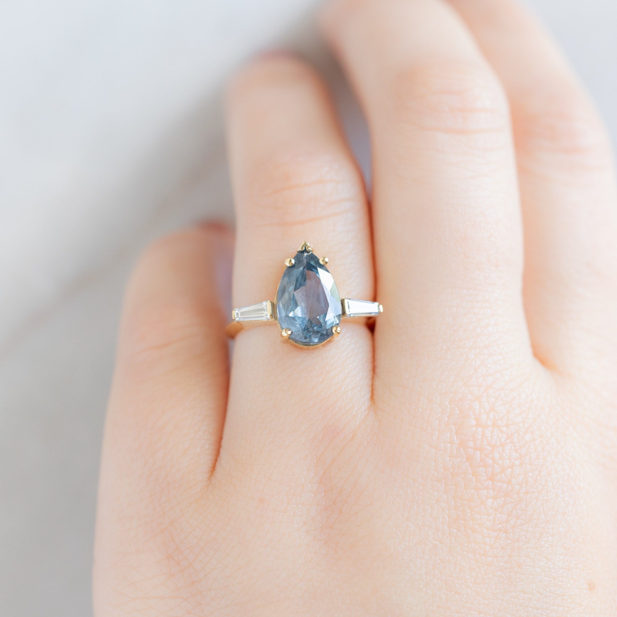 The Ash Luxe with a 3.62ct Pear Cut Sapphire in 18K Yellow Gold on Model