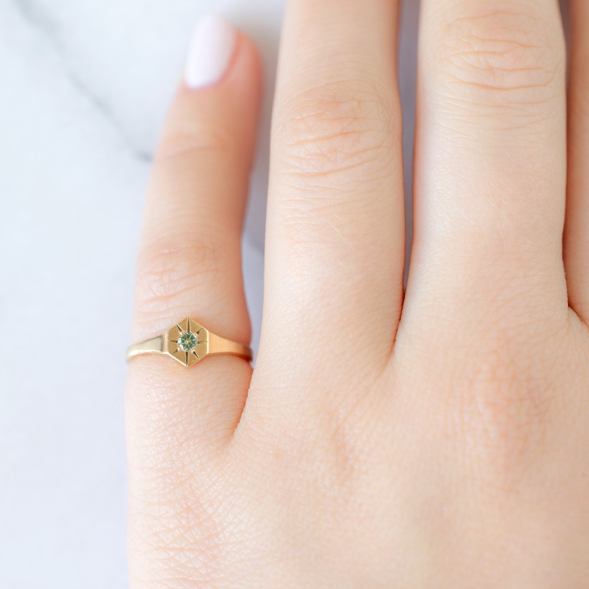 Custom Peridot Birthstone Signet Ring | 10K Yellow Gold. Displayed on model's left hand pinky finger. 