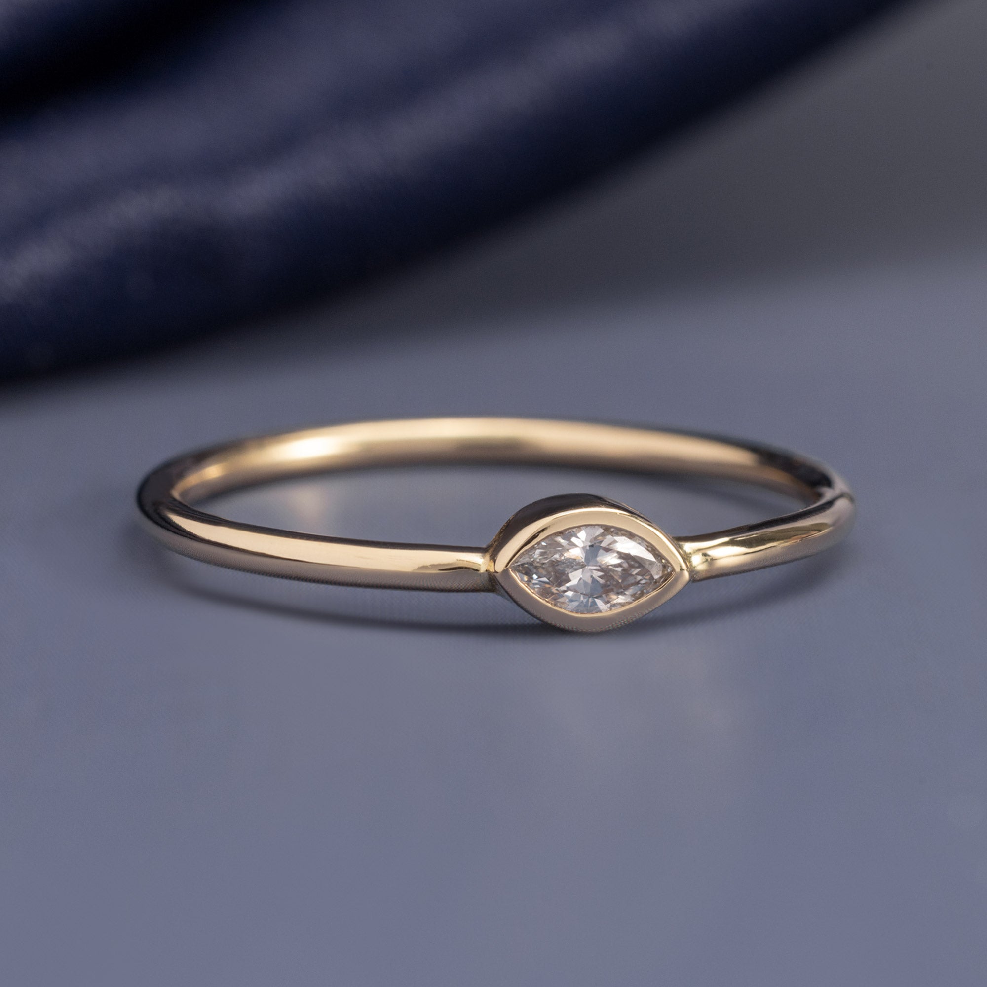 Marquise Diamond Stacking Ring in 10K Yellow Gold on Muted Blue Background