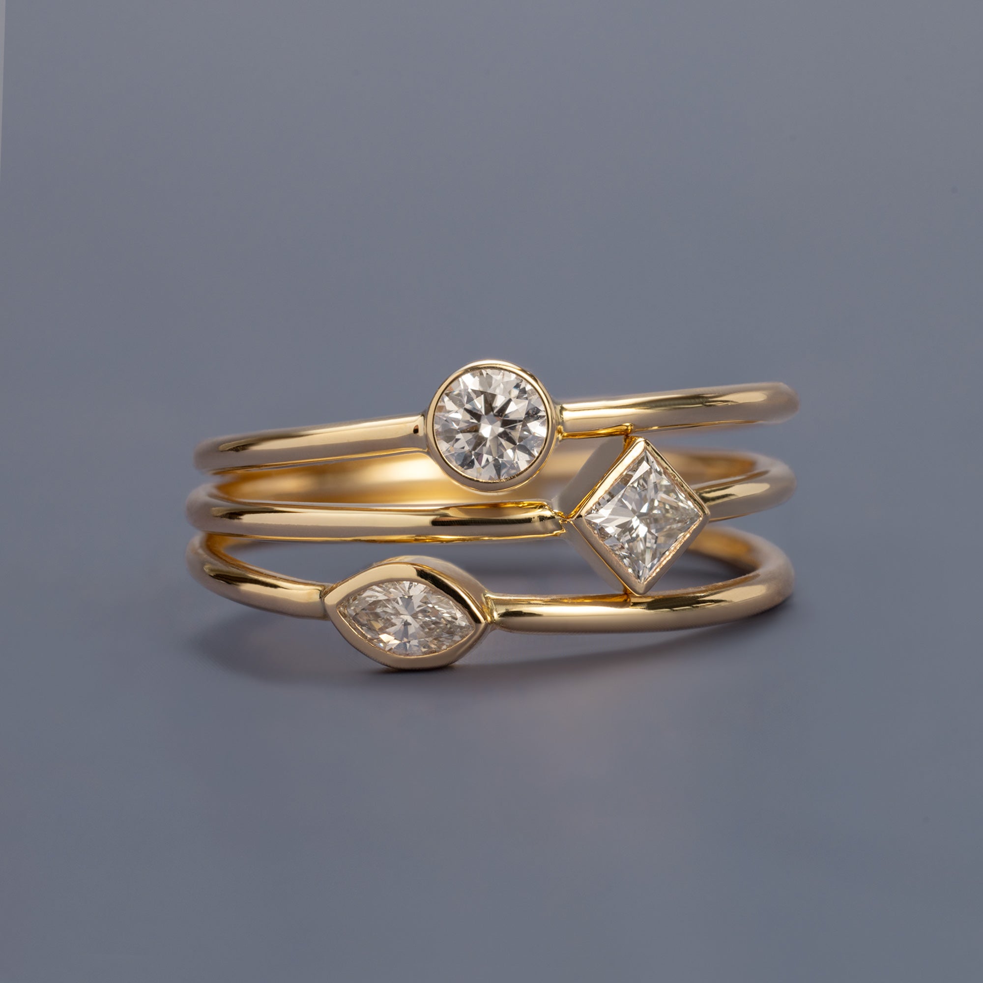 Lab Grown Diamond Stacking Rings in 10K Yellow Gold on Muted Blue Background