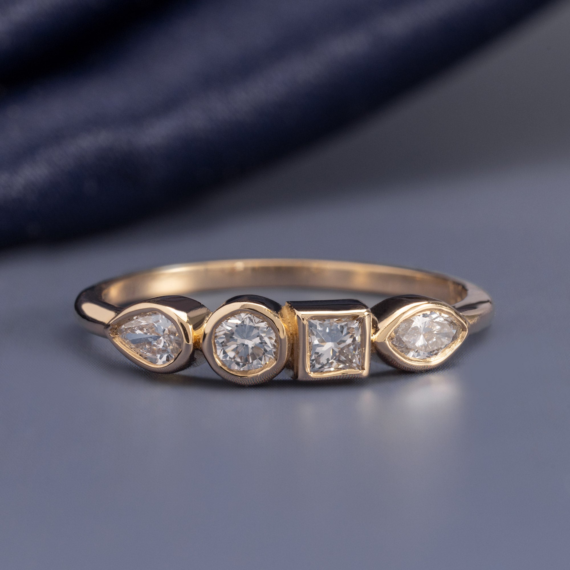 Diamond Squad Stacking Ring in 10K Yellow Gold on muted blue background