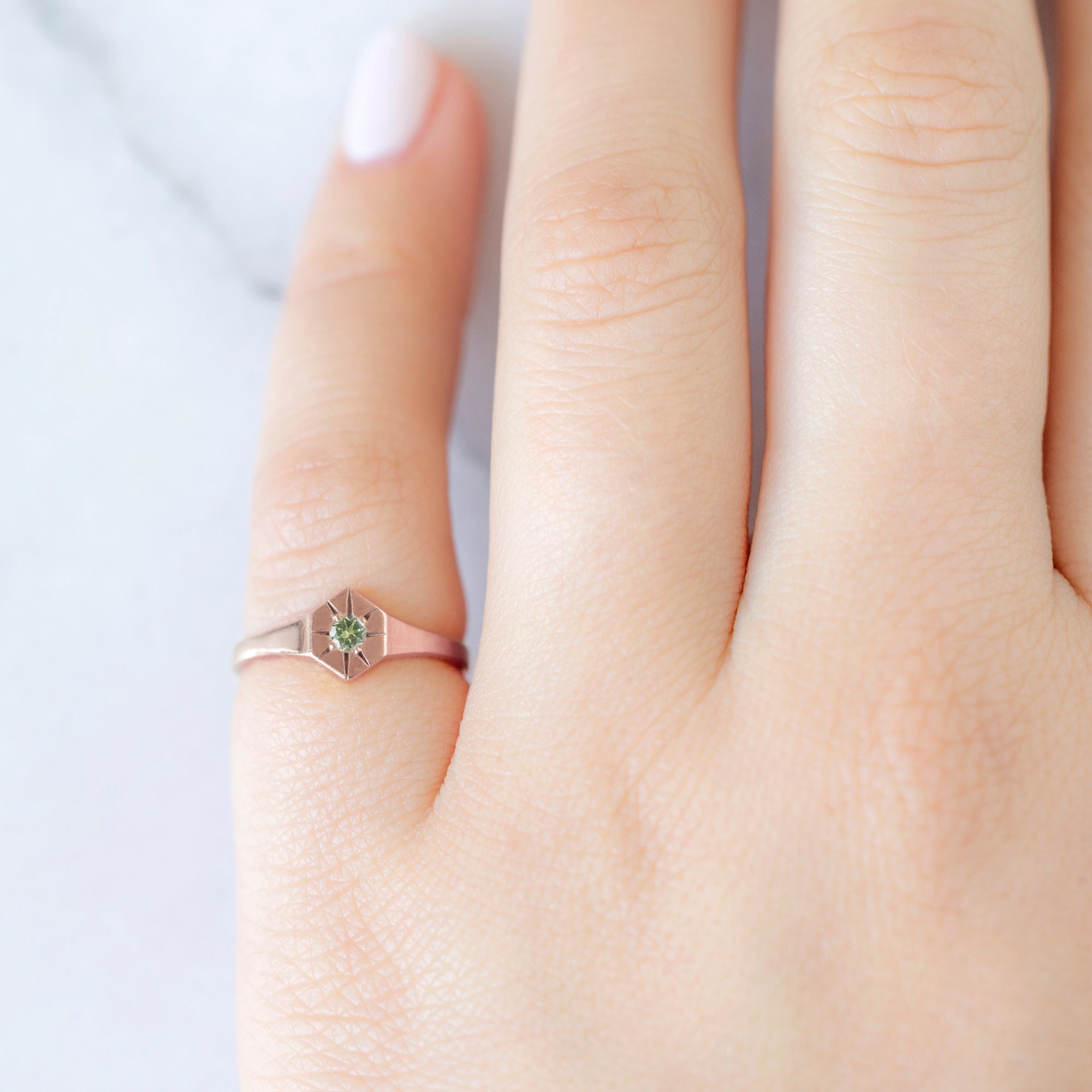 Custom Peridot Birthstone Signet Ring | 10K Rose Gold. Displayed on model's left hand pinky finger.