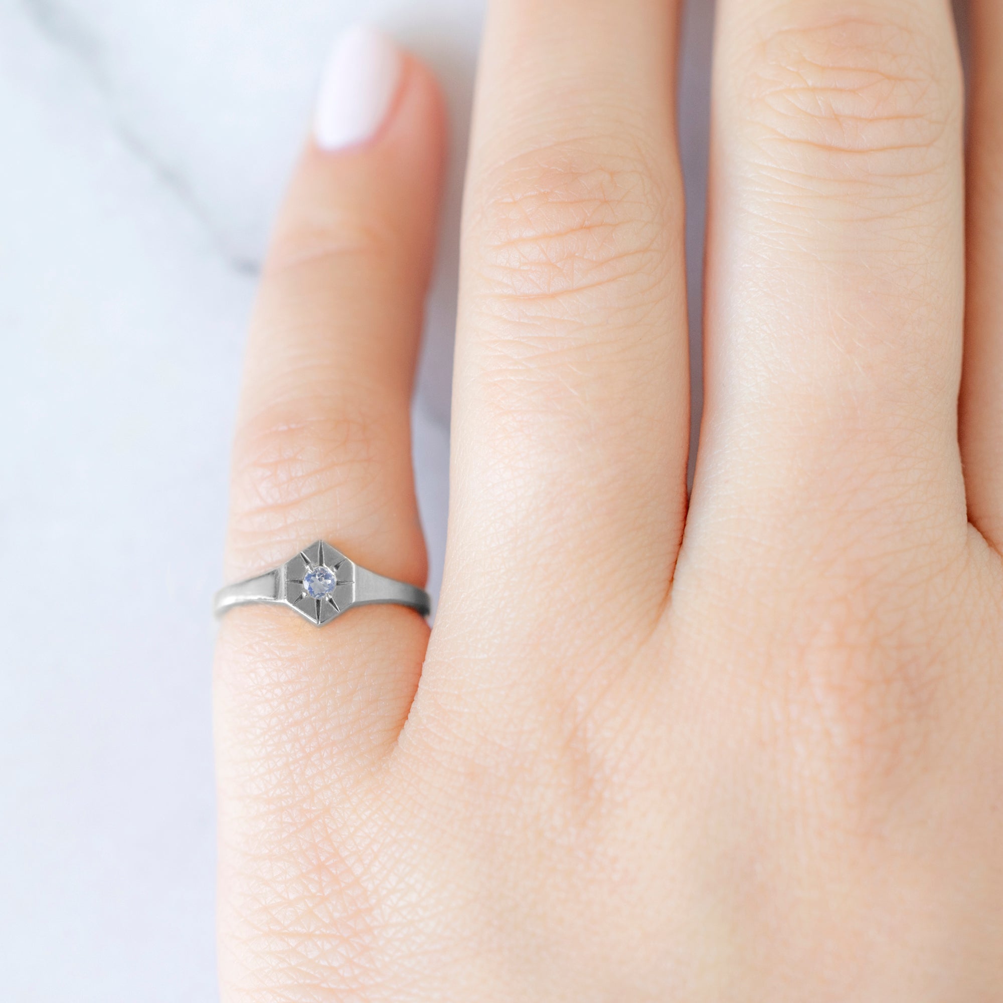 Custom Moonstone Birthstone Signet Ring | 10K White Gold. Displayed on model's left hand pinky finger.