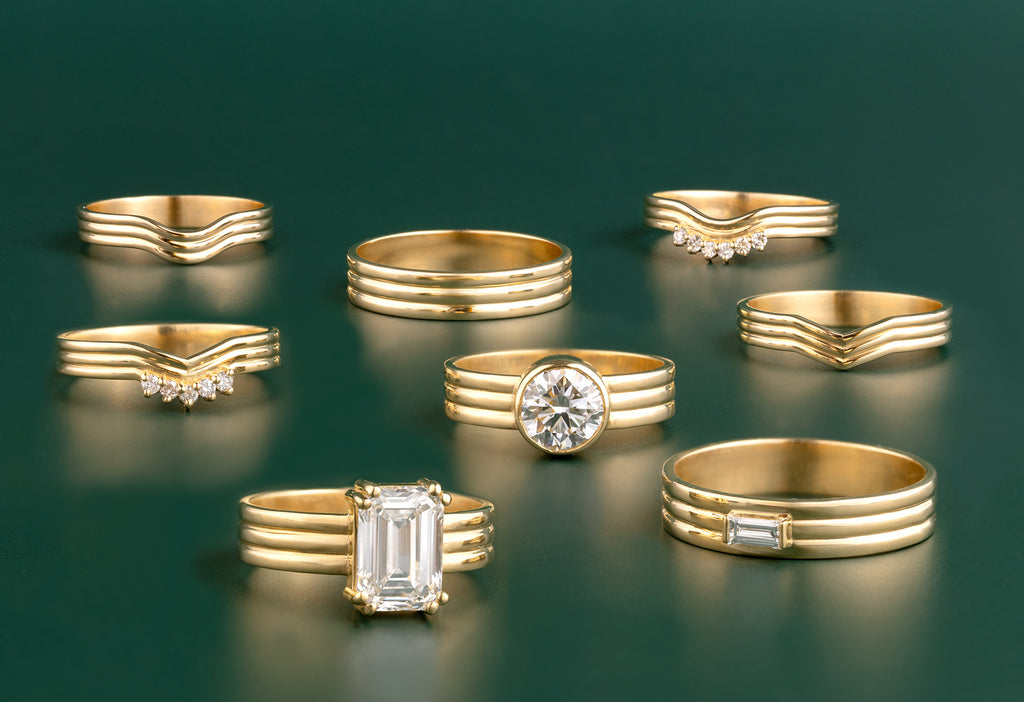 Full 18k Yellow Gold Engagement + Wedding Band Collection on Green Background