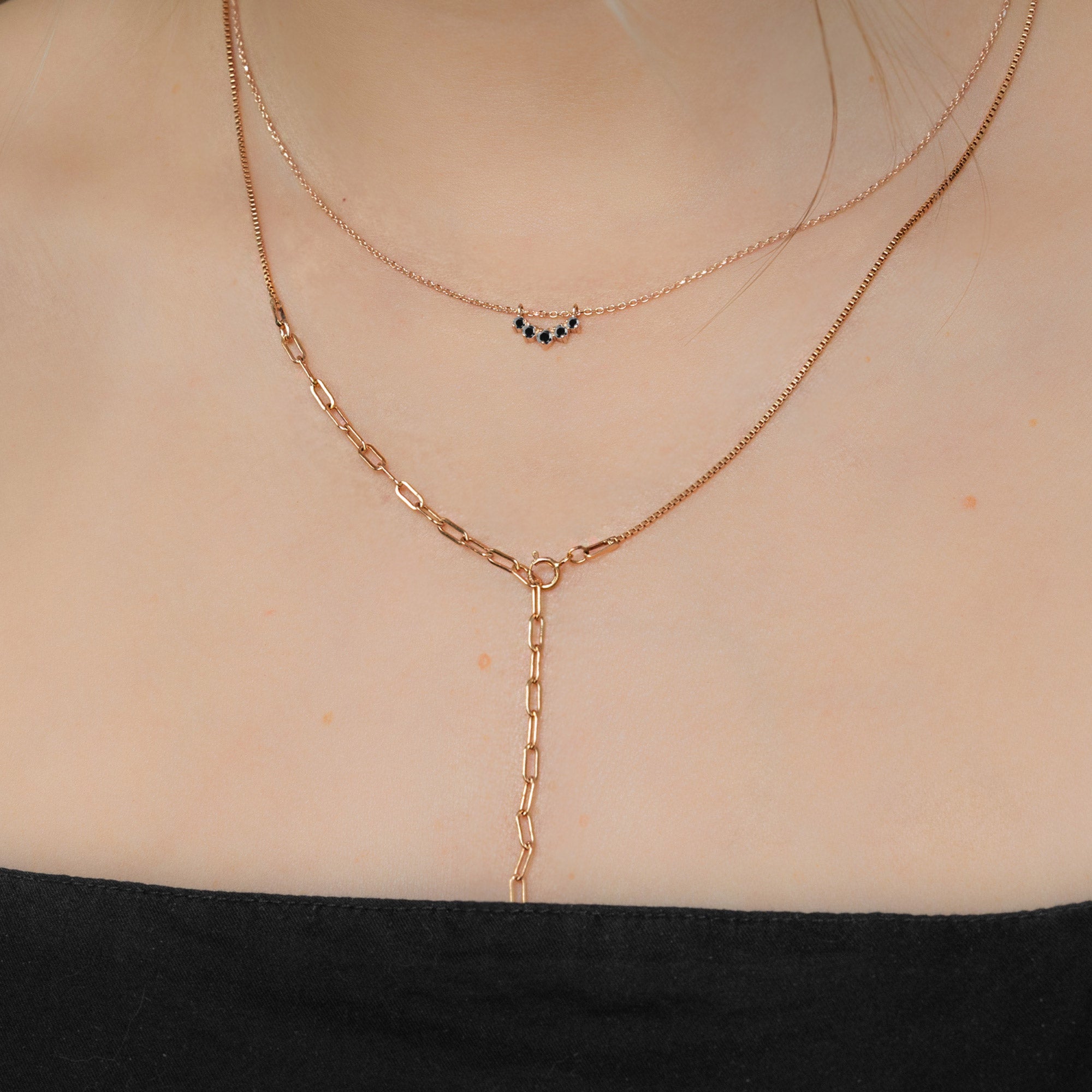 Custom Black Diamond Sunburst Necklace | 10K Rose Gold displayed on model's neck paired with another chain.