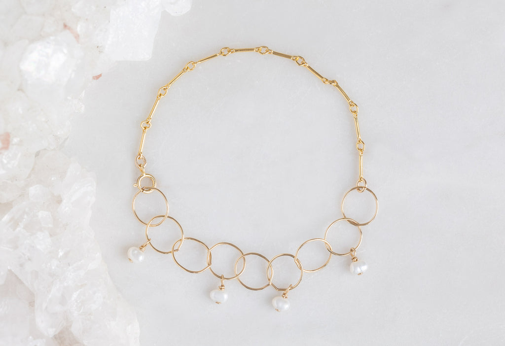 Yellow Gold Pearl Party Chain Bracelet on White Marble