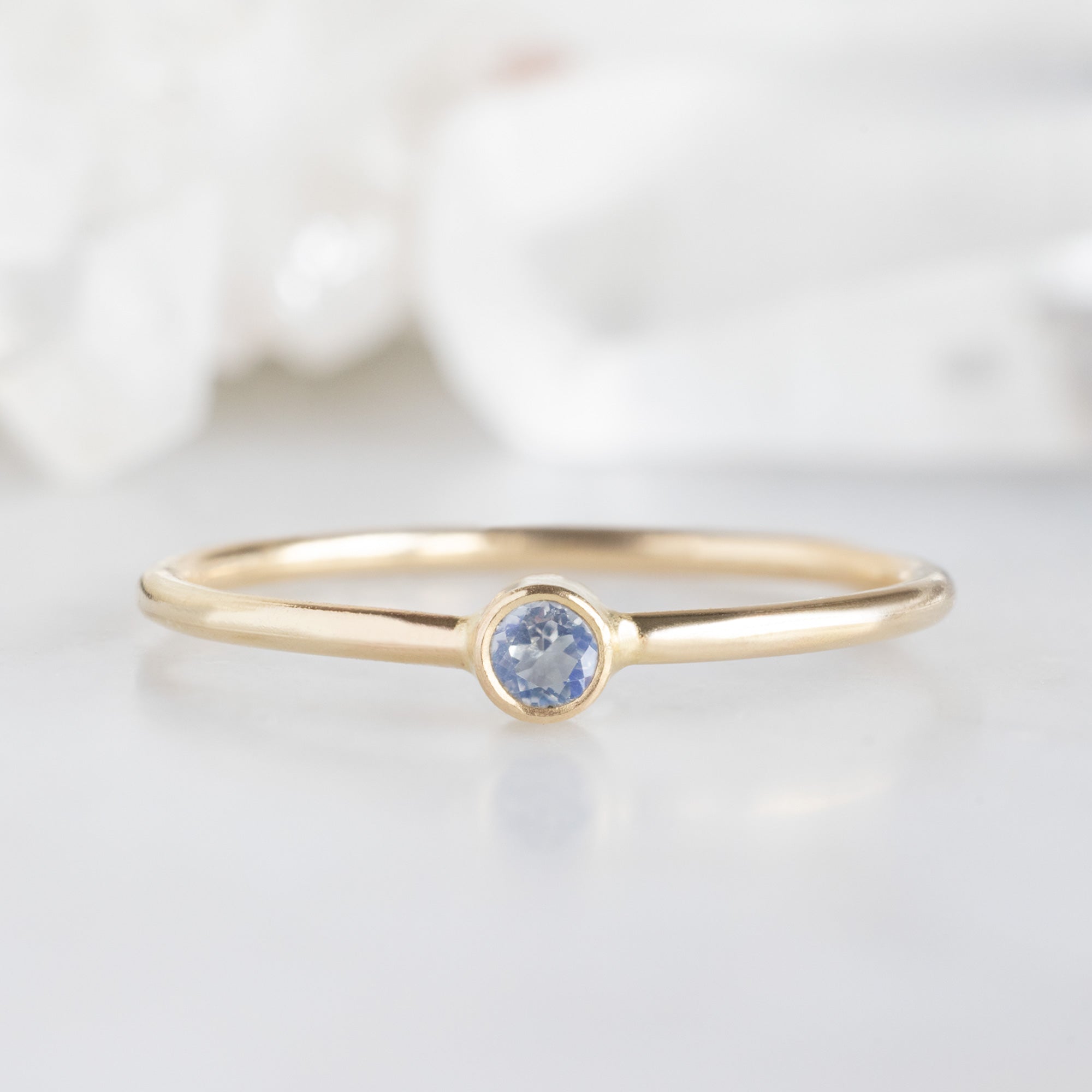 Custom Moonstone Birthstone Stacking Ring | 10K Yellow Gold with blurred background. 