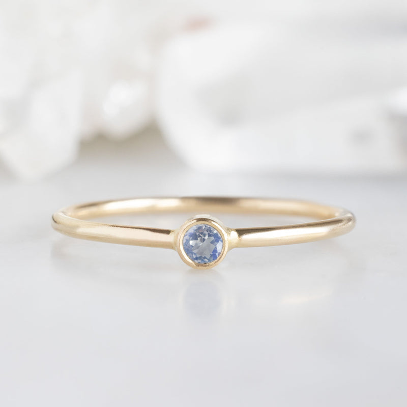 Custom Moonstone Birthstone Stacking Ring | 10K Yellow Gold with blurred background. 