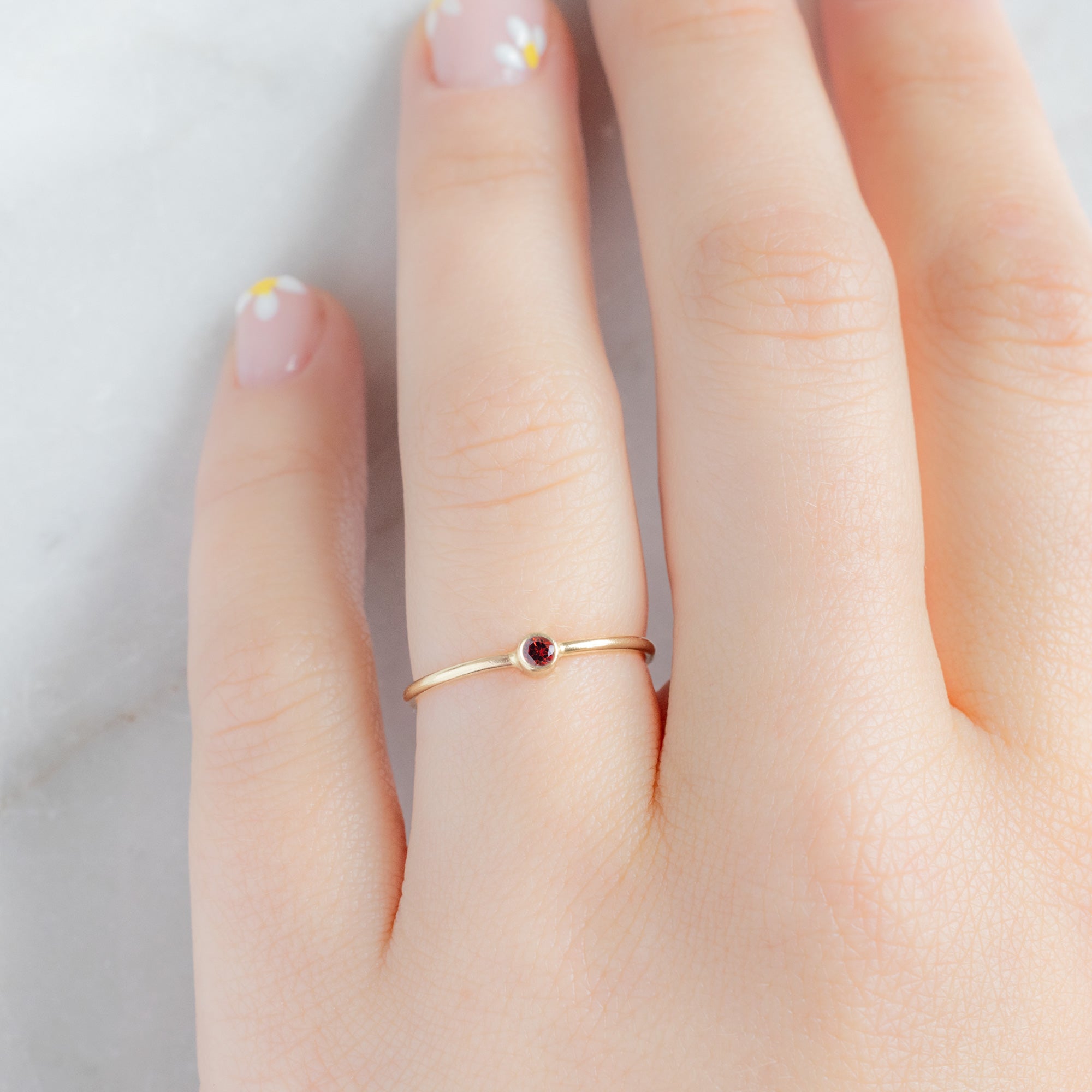 Custom Garnet Birthstone Stacking Ring | 10K Yellow Gold. Displayed on model's left hand ring finger. 