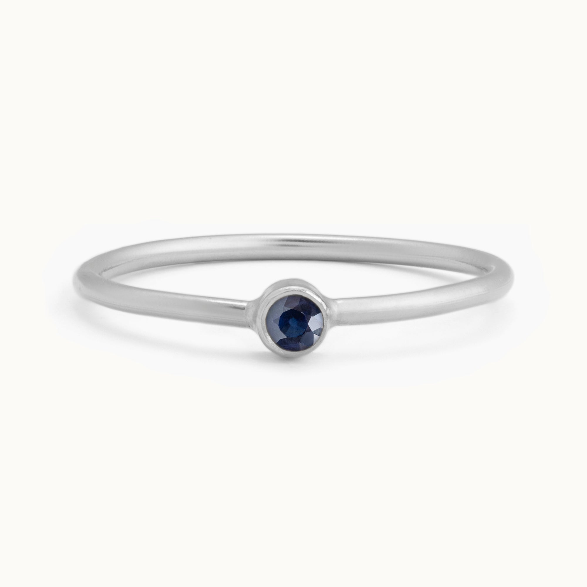 Custom Blue Sapphire Birthstone Stacking Ring | 10K White Gold with white background.
