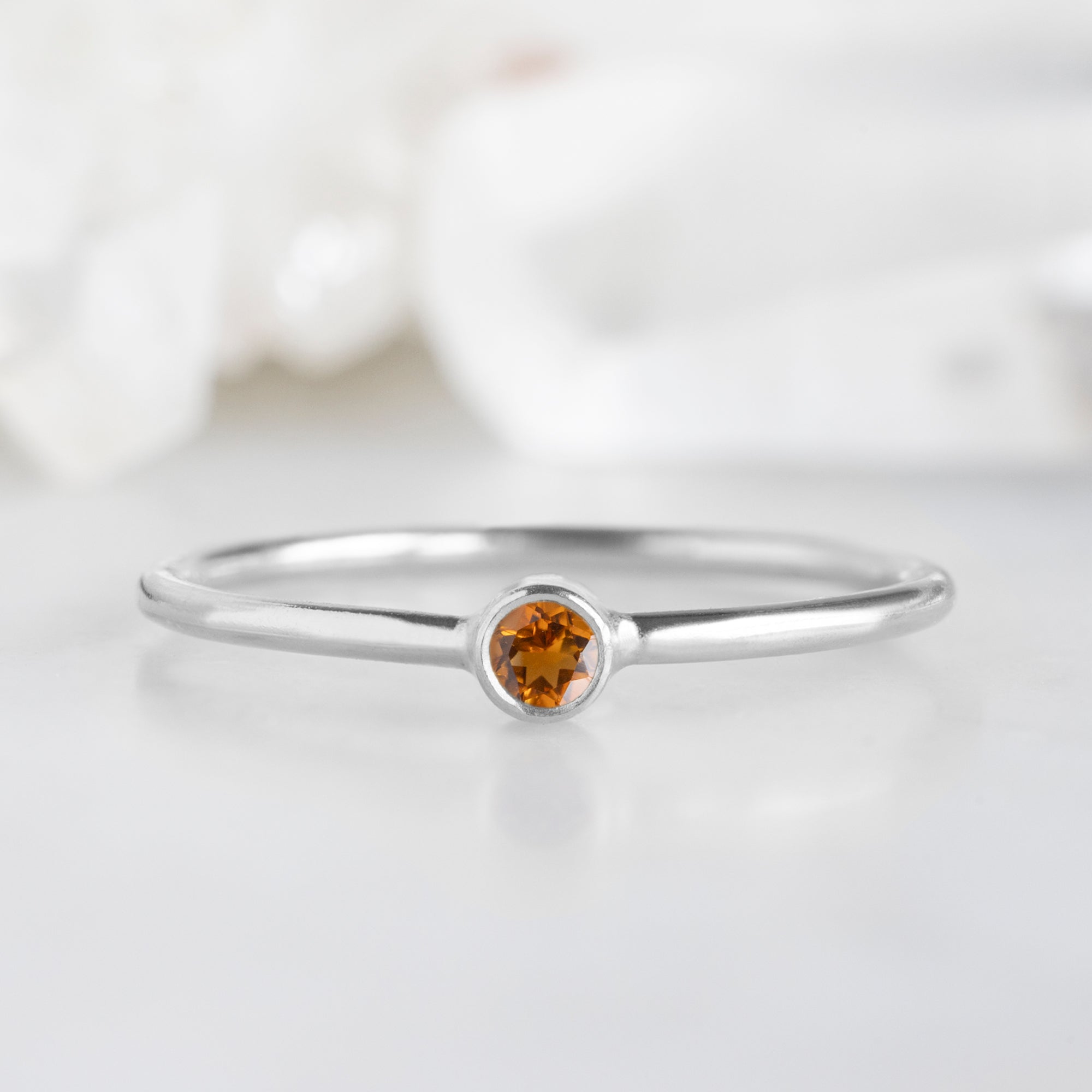 Custom Citrine Birthstone Stacking Ring | 10K White Gold displayed on marble surface with white blurred background. 